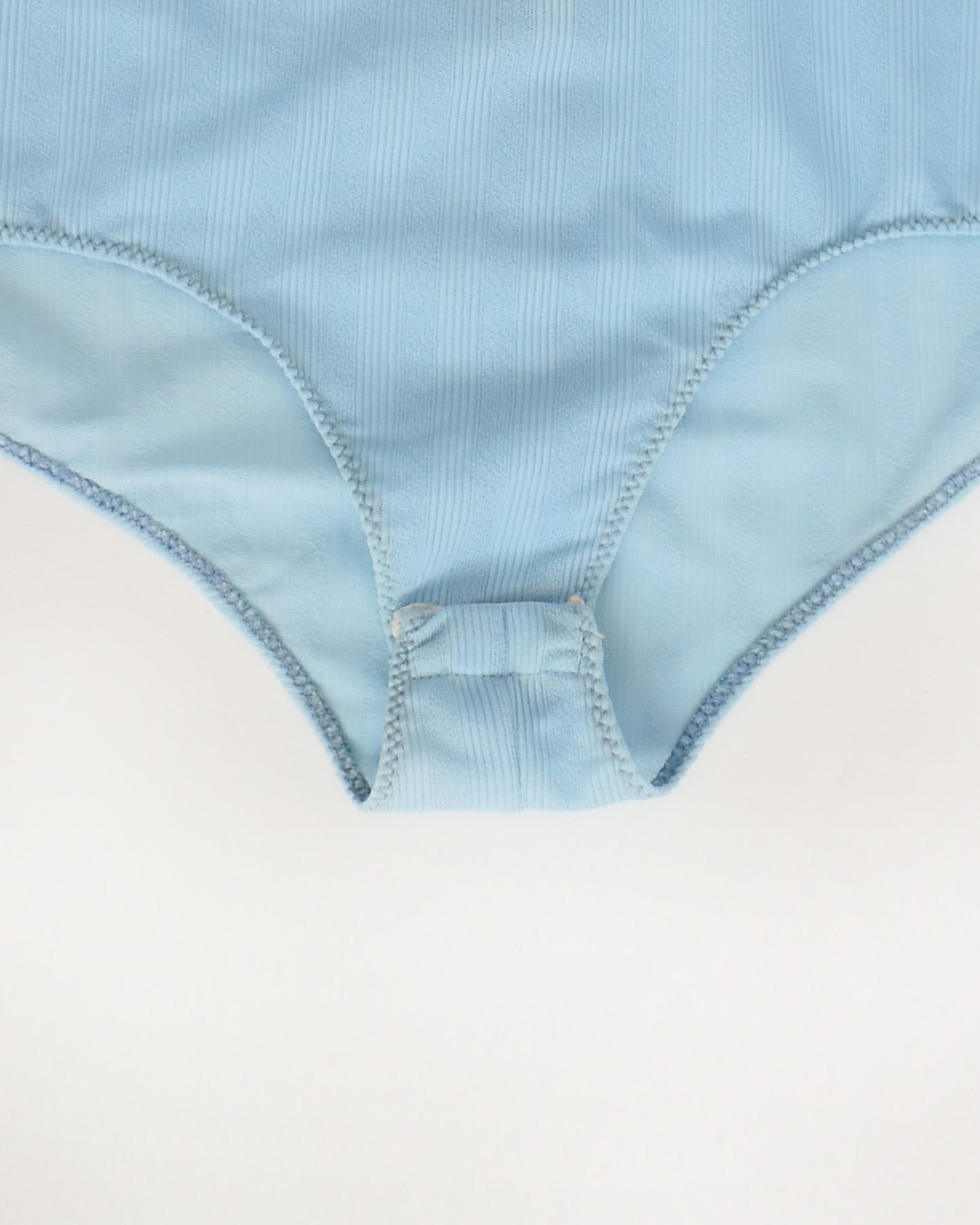 close up of the snap crotch on a vintage 1970s light blue long-sleeve bodysuit