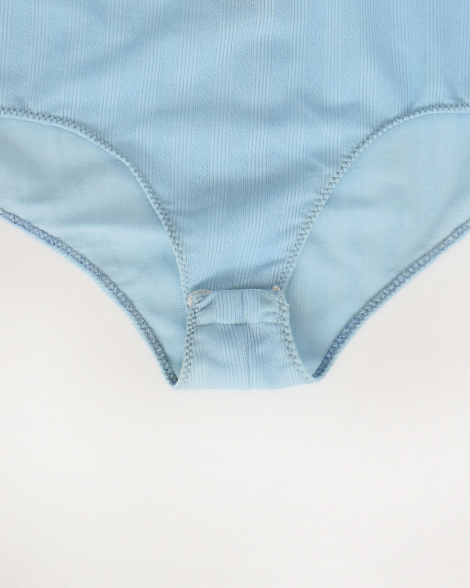 close up of the snap crotch on a vintage 1970s light blue long-sleeve bodysuit