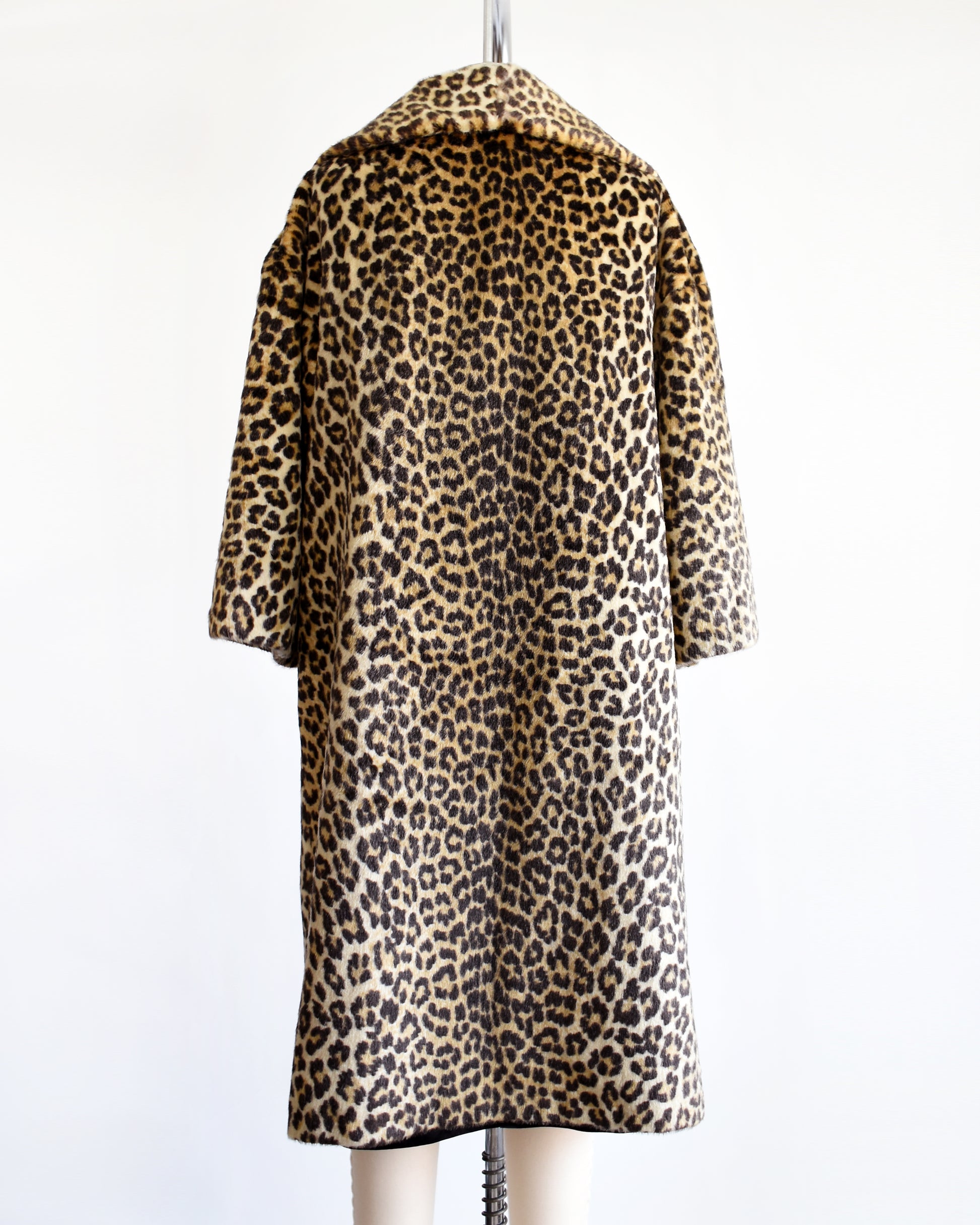 Back view of a vintage 1960s faux fur leopard print coat on a dress form