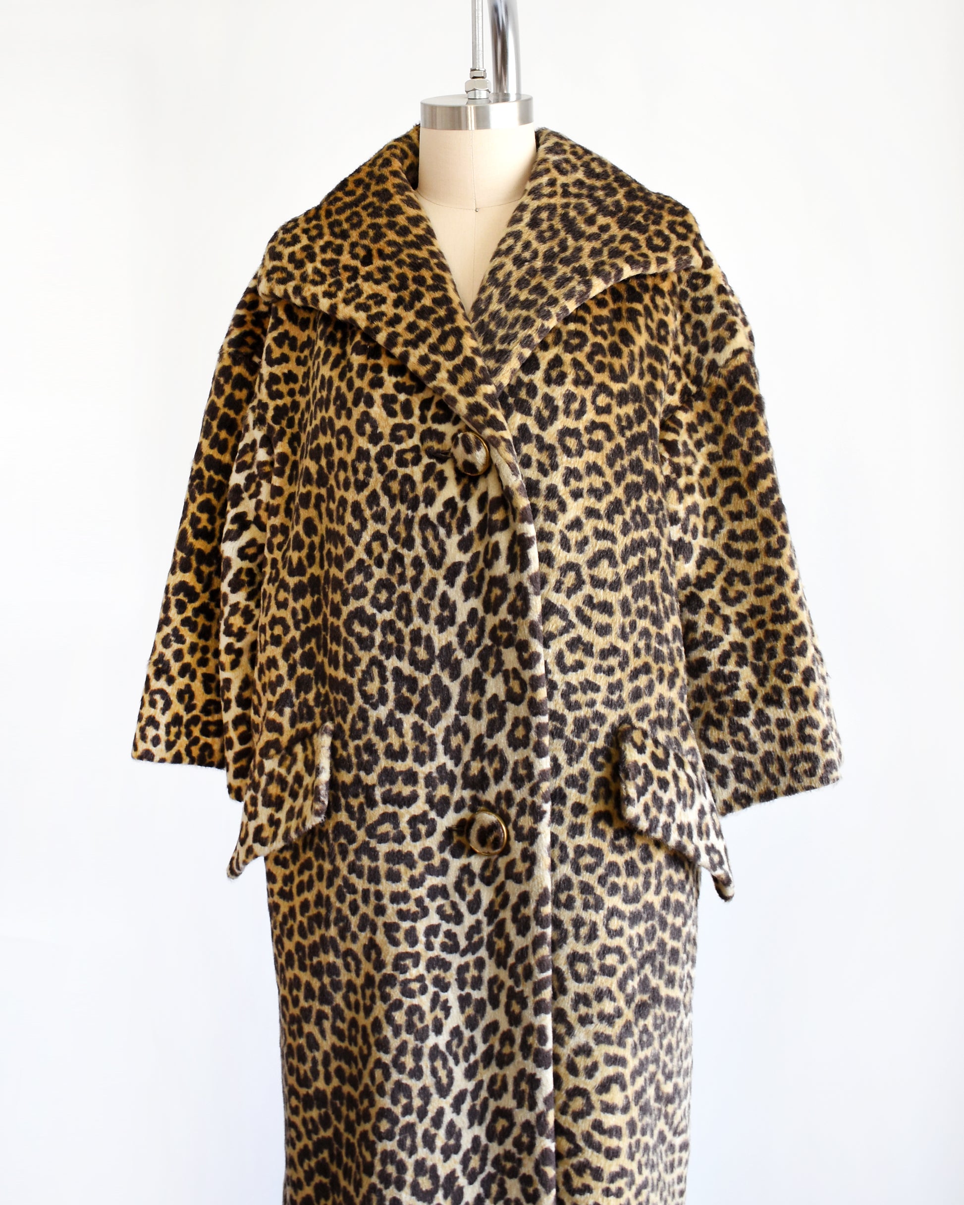 Side front view of a vintage 1960s faux fur leopard print coat on a dress form