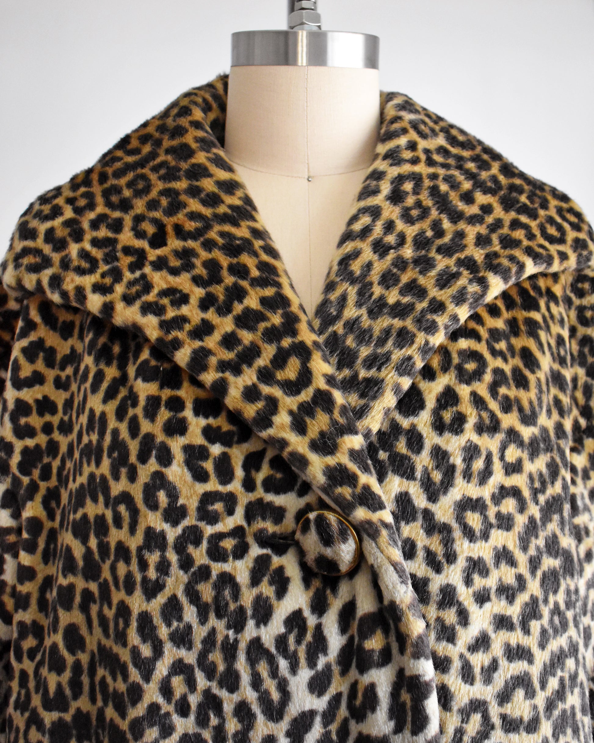 Close up of the collar of a vintage 1960s faux fur leopard print coat on a dress form