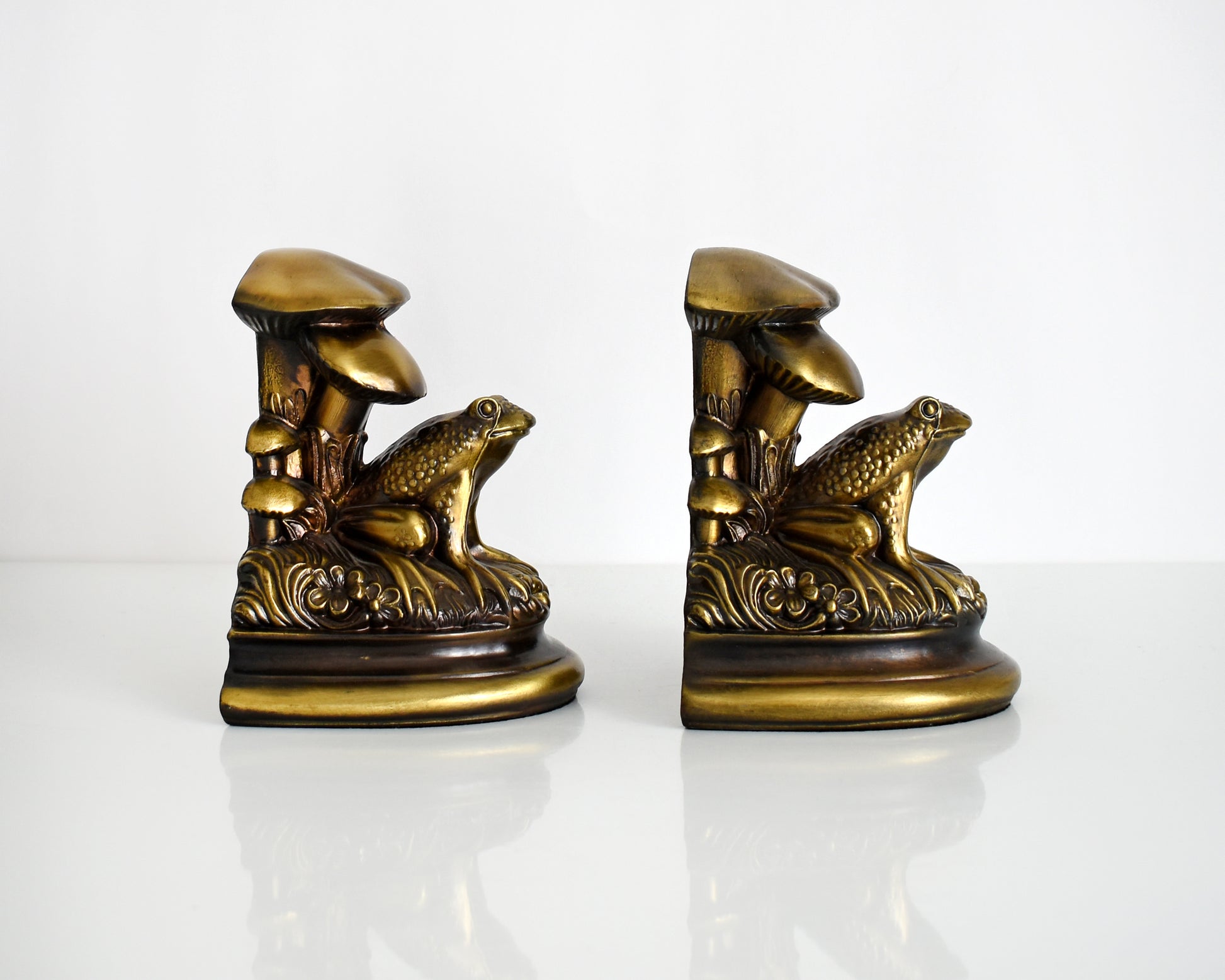 Side view of  vintage brass frog and mushroom bookends