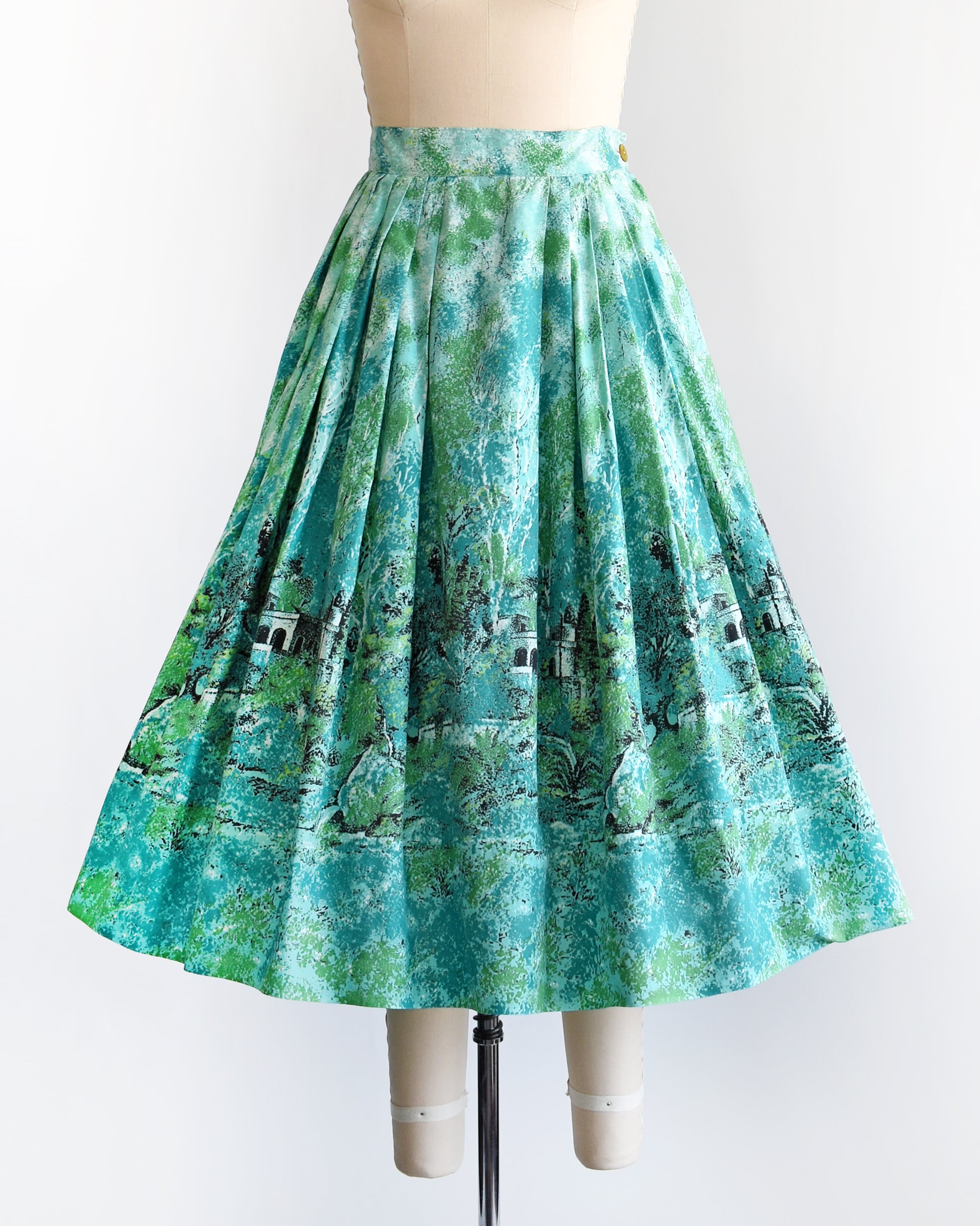 A vintage 1950s blue and green novelty print skirt that has a scenic forest and chateau border print scene.