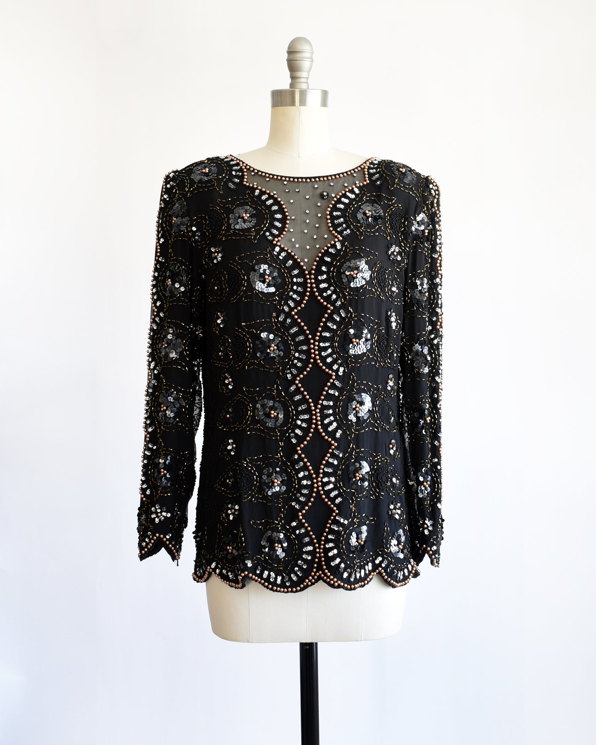 a vintage 1980s black sequin and beaded top on a mannequin against a white background