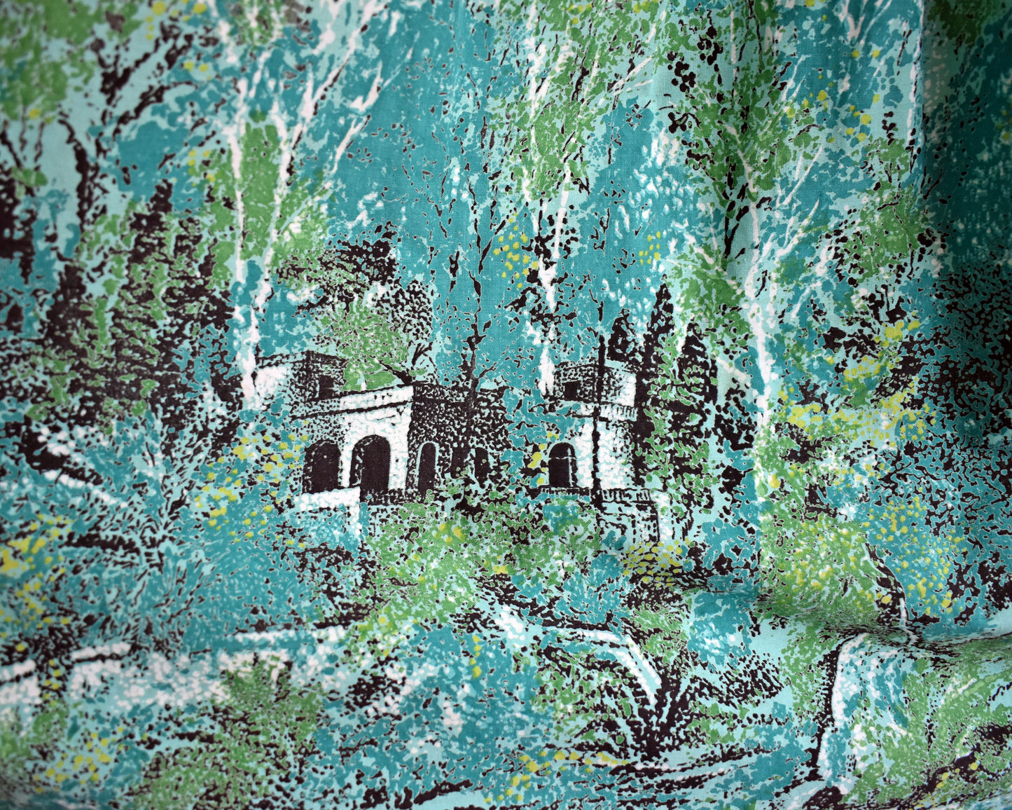 close up of the scenic novelty print which includes lots of trees an a chateau looking abode