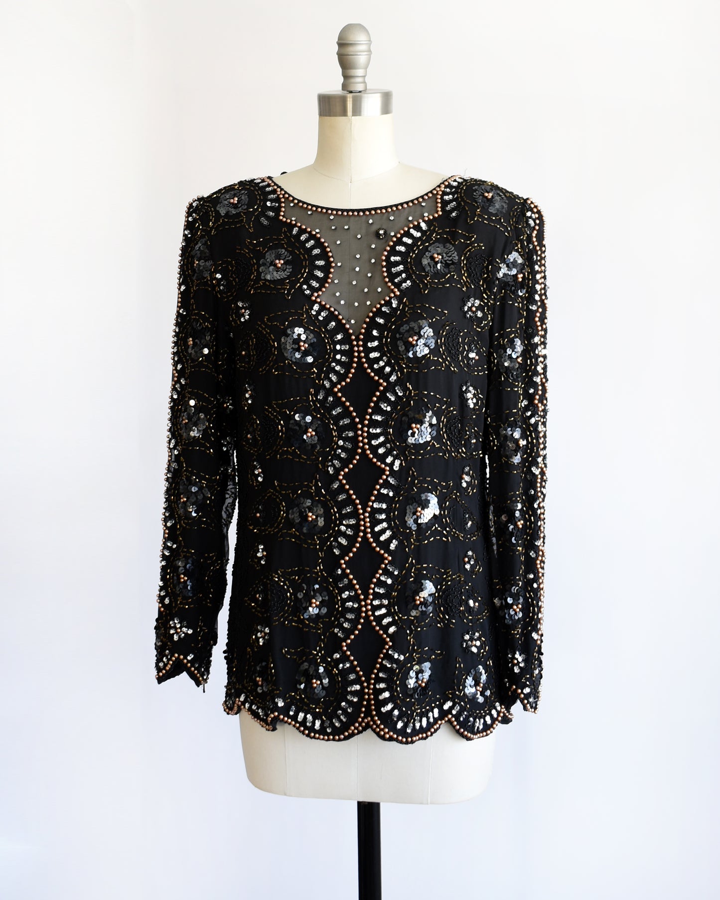 side front view of a vintage 1980s black sequin and beaded top on a mannequin against a white background