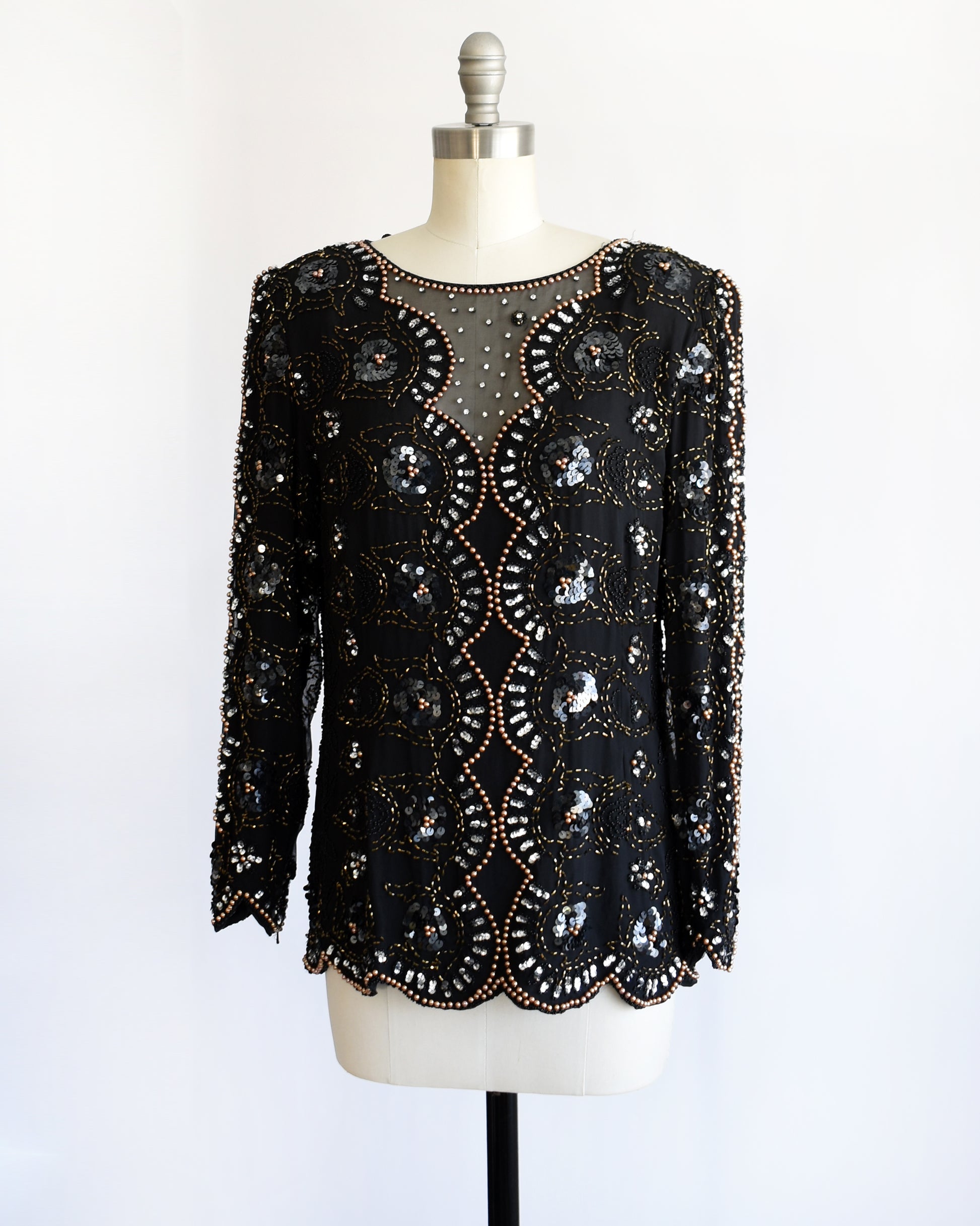 side front view of a vintage 1980s black sequin and beaded top on a mannequin against a white background