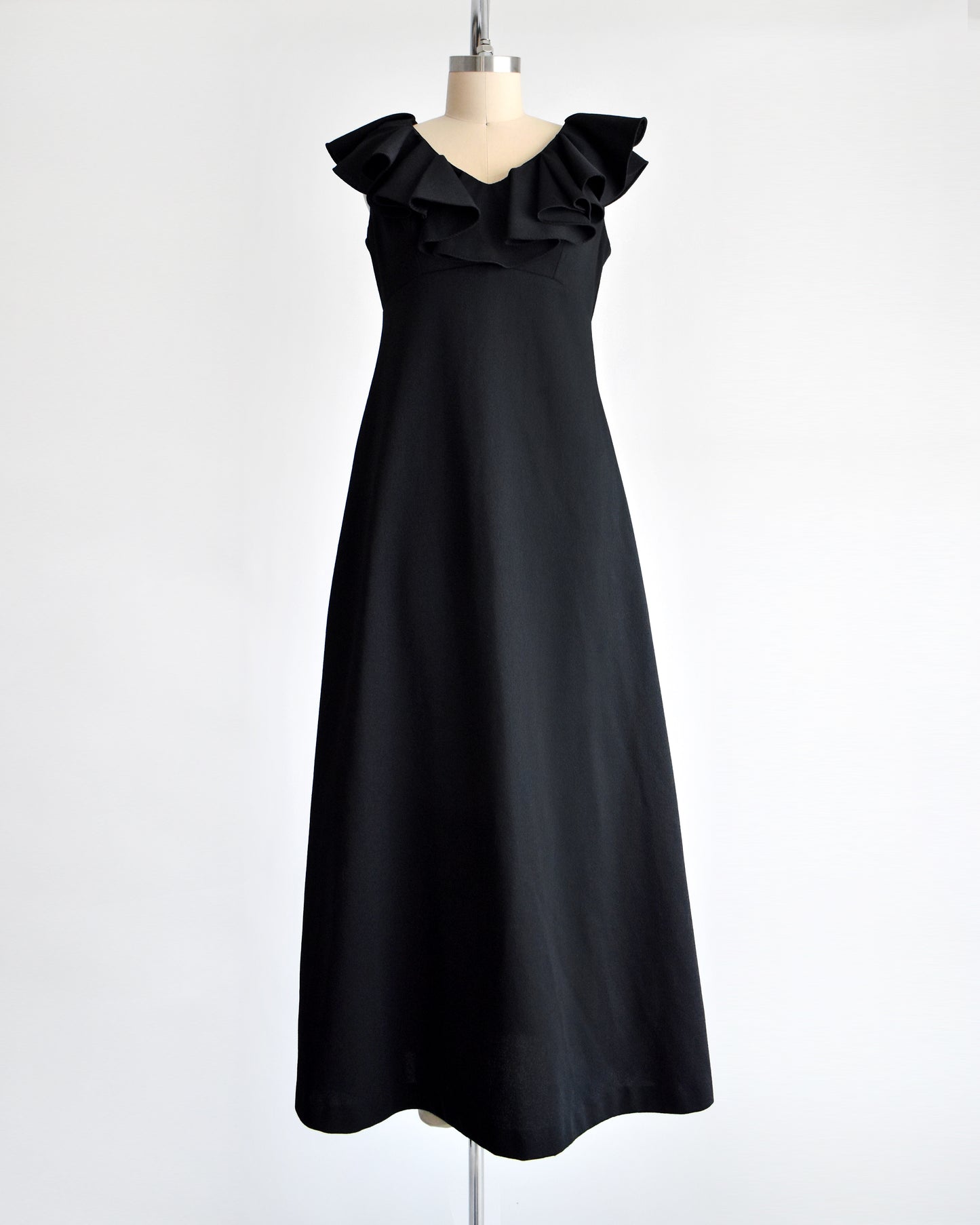 A vintage black 1970s maxi dress with a ruffled neckline.