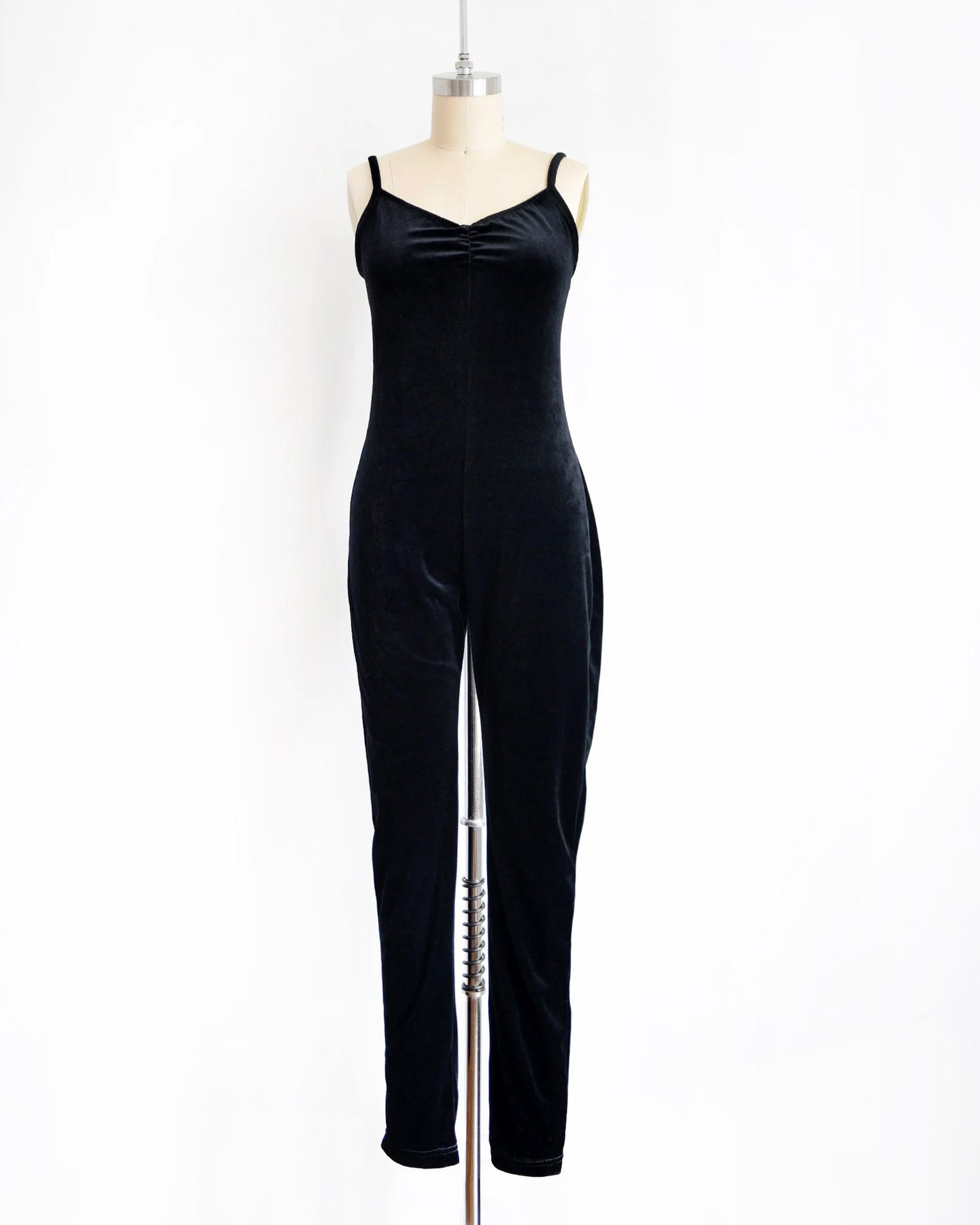 A black velvet jumpsuit displayed on a mannequin against a plain white background.