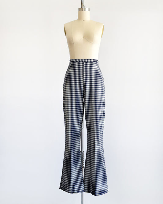 A pair of vintage 1970s blue and white gingham bell bottom pants on a dress form