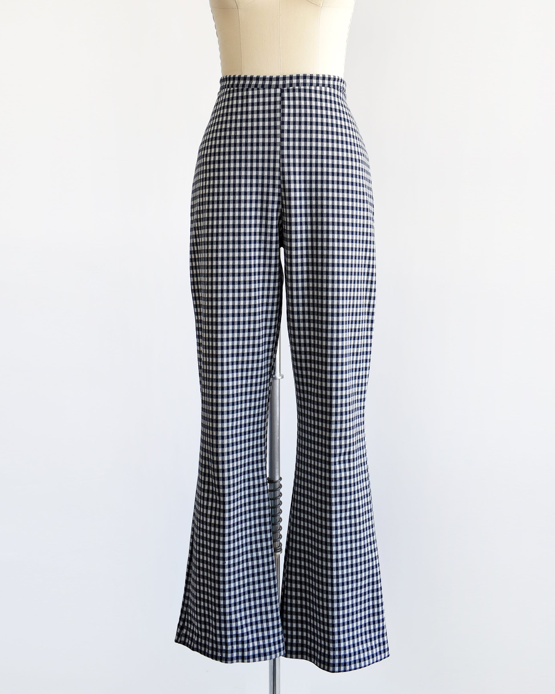 A pair of vintage 1970s blue and white gingham bell bottom pants on a dress form