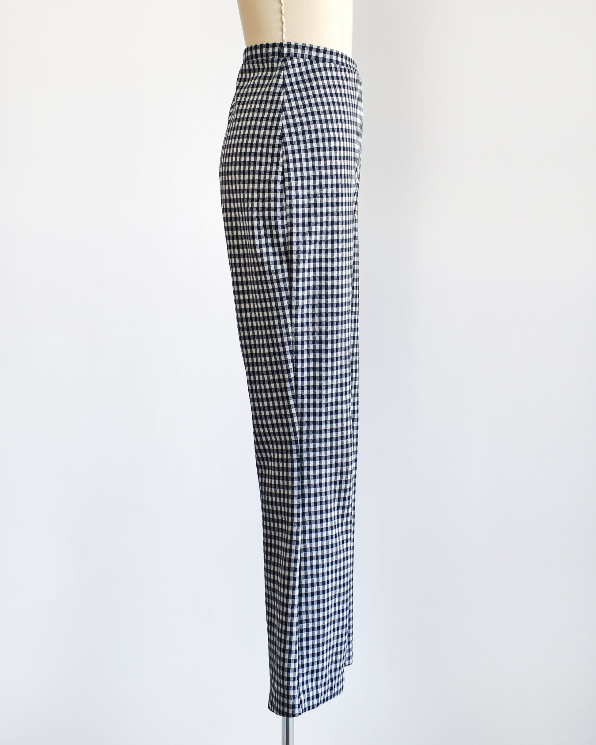 side view of a pair of vintage 1970s blue and white gingham bell bottom pants on a dress form