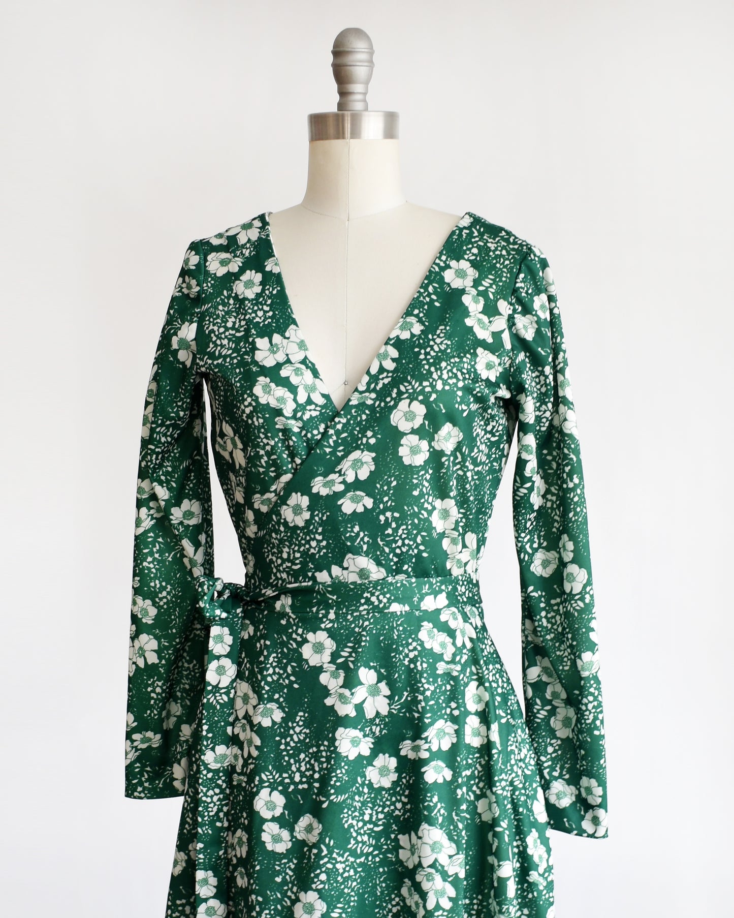 side front view of a vintage 70s green and white floral wrap dress