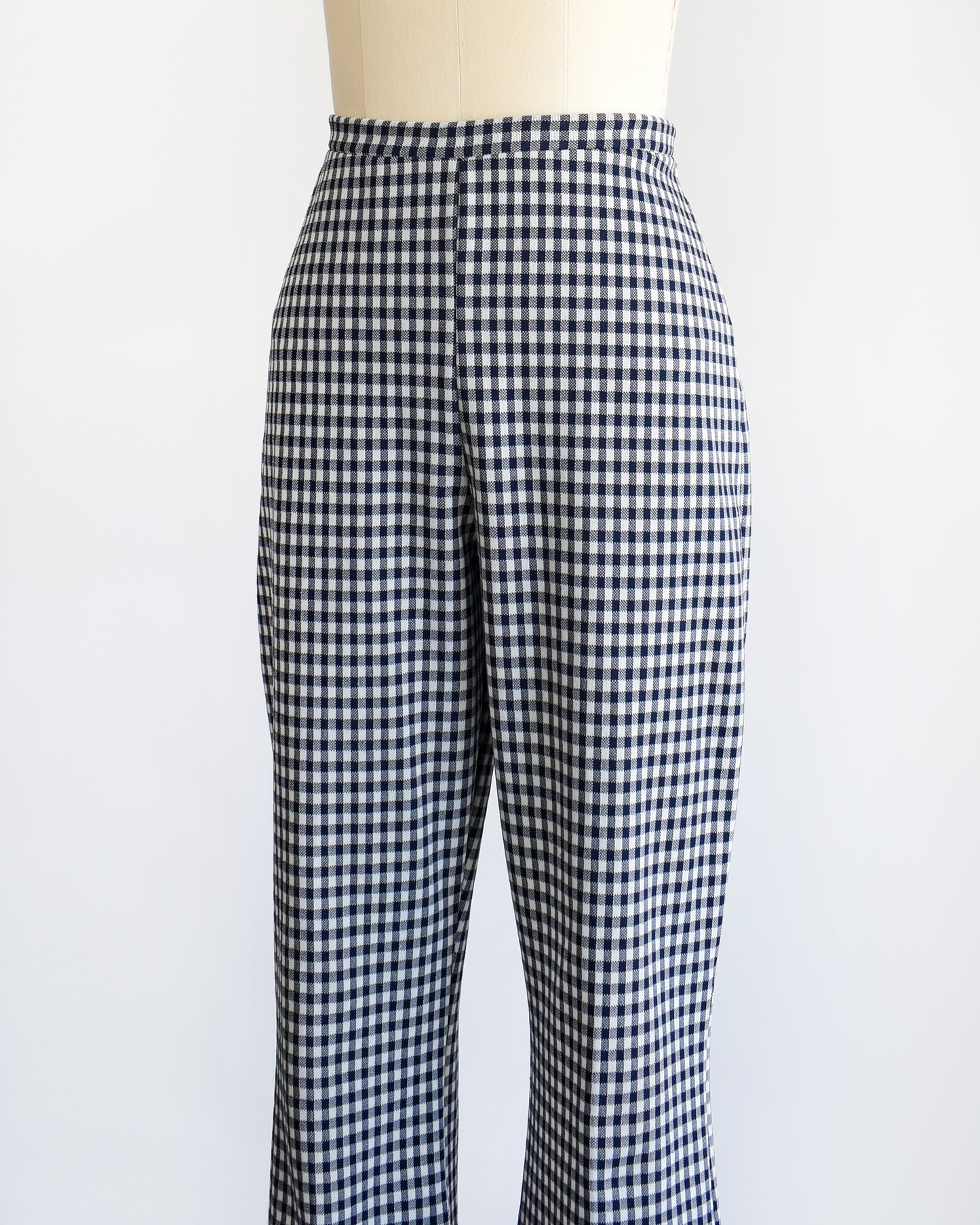 side front view of a pair of vintage 1970s blue and white gingham bell bottom pants on a dress form