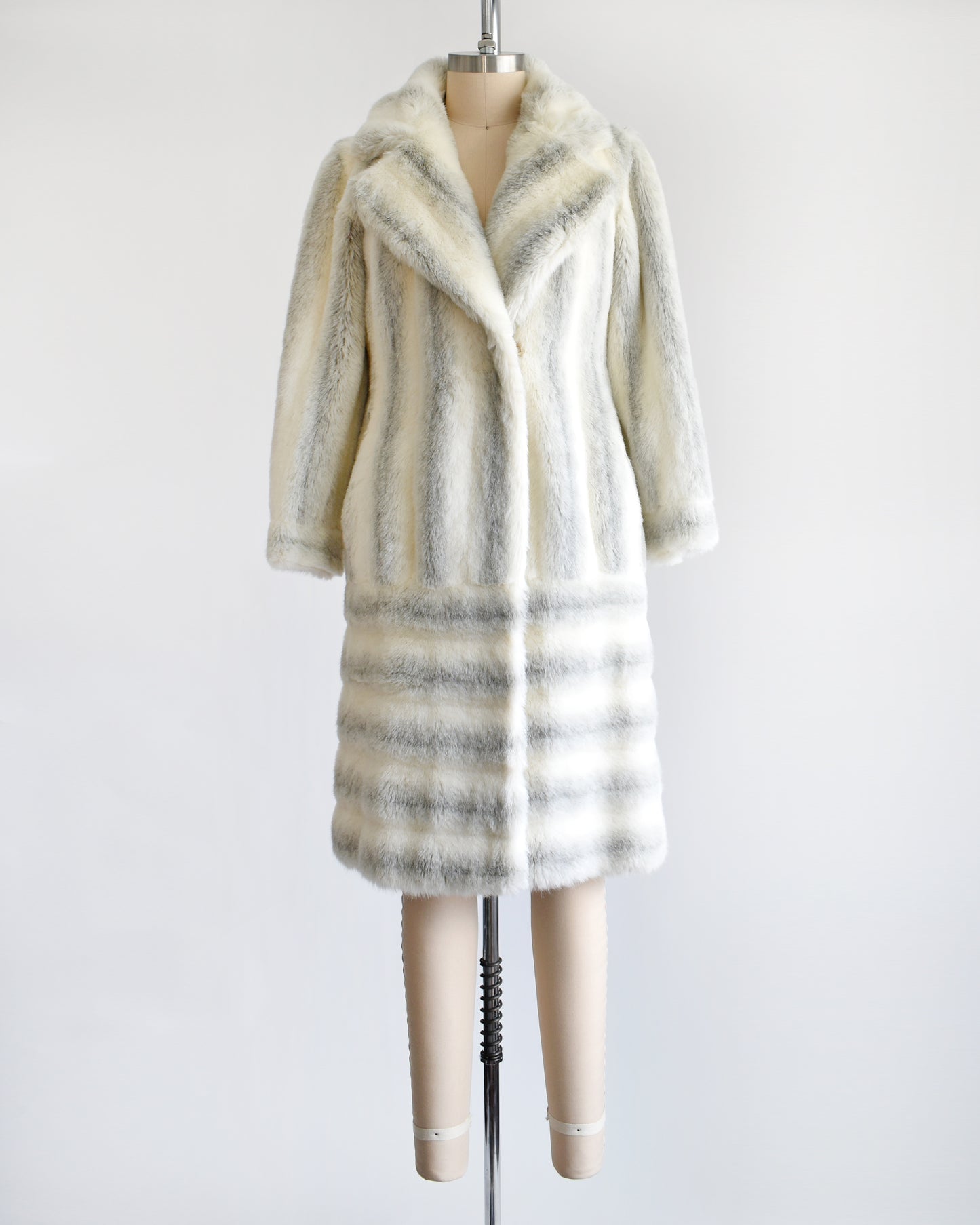 A vintage 1970s white and gray striped faux fur coat on a dress form