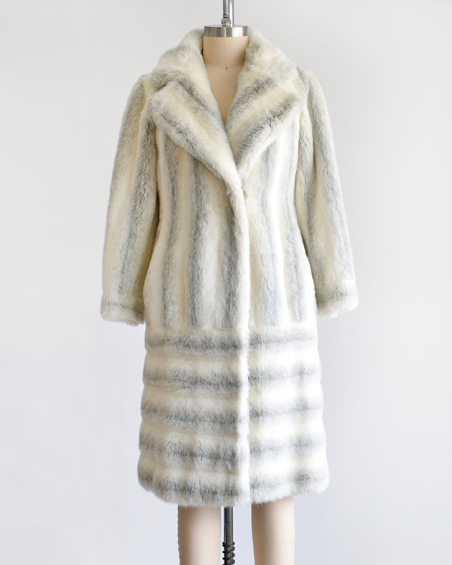 A vintage 1970s white and gray striped faux fur coat on a dress form