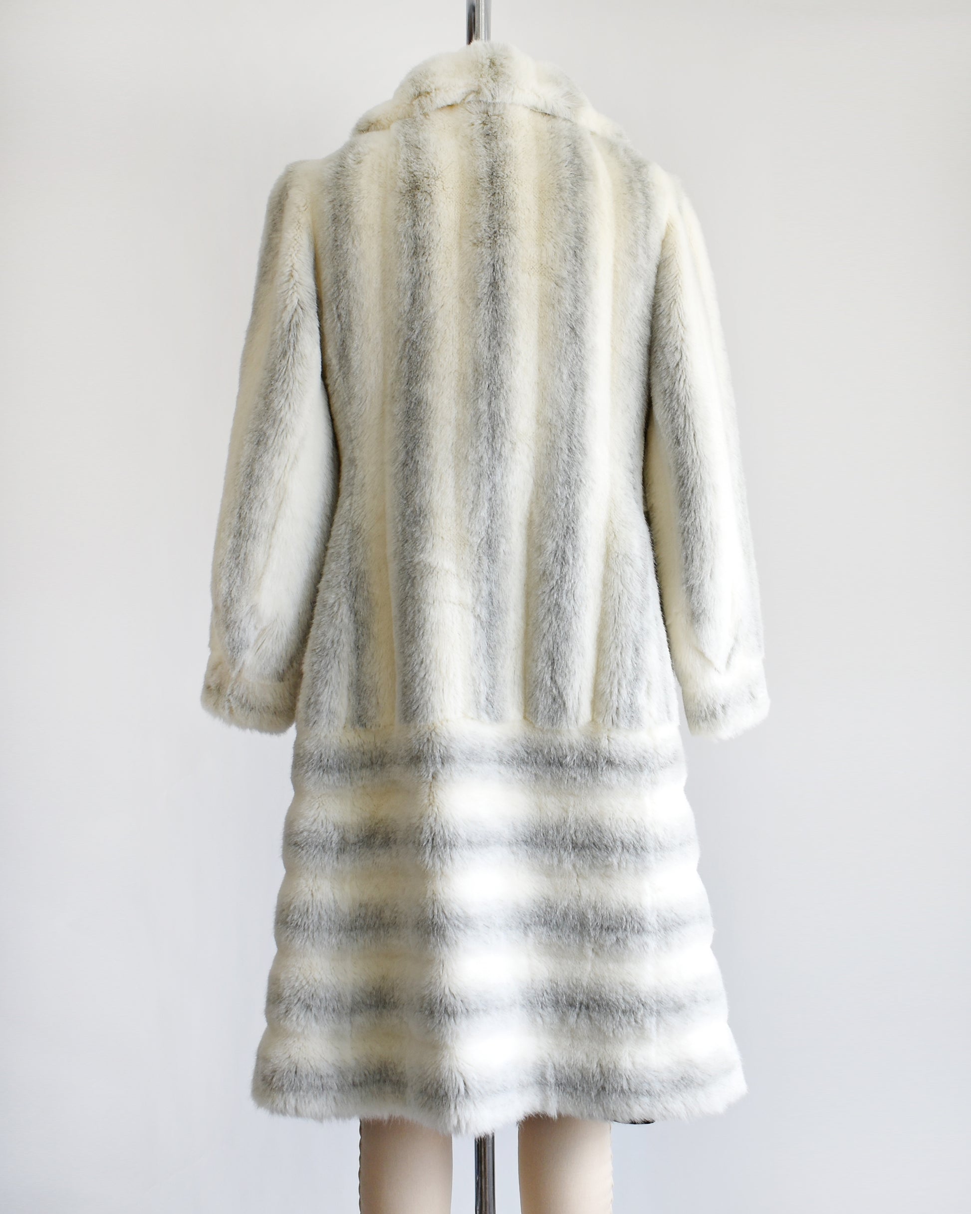 back view of a vintage 1970s white and gray striped faux fur coat on a dress form