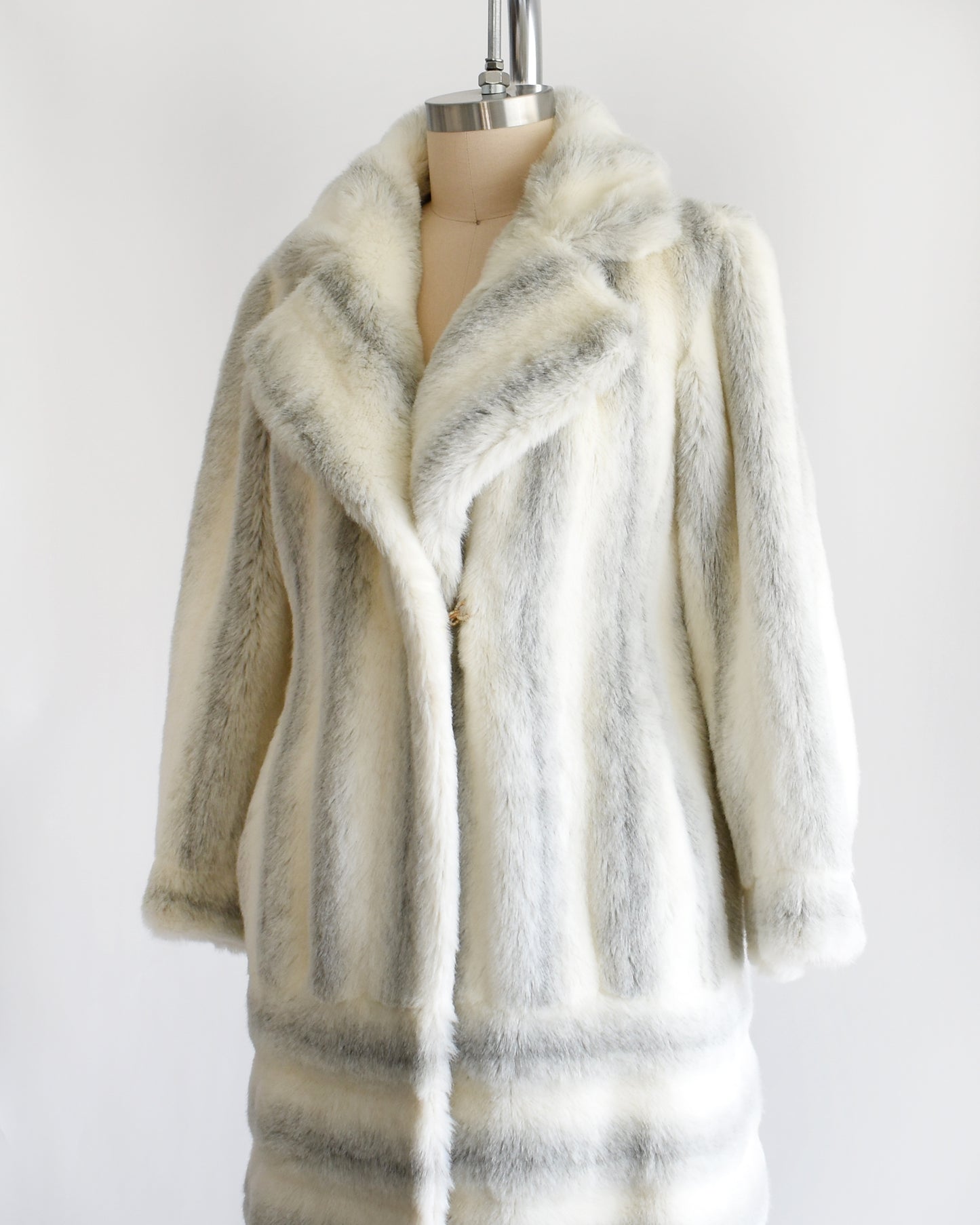 side front view of a vintage 1970s white and gray striped faux fur coat on a dress form