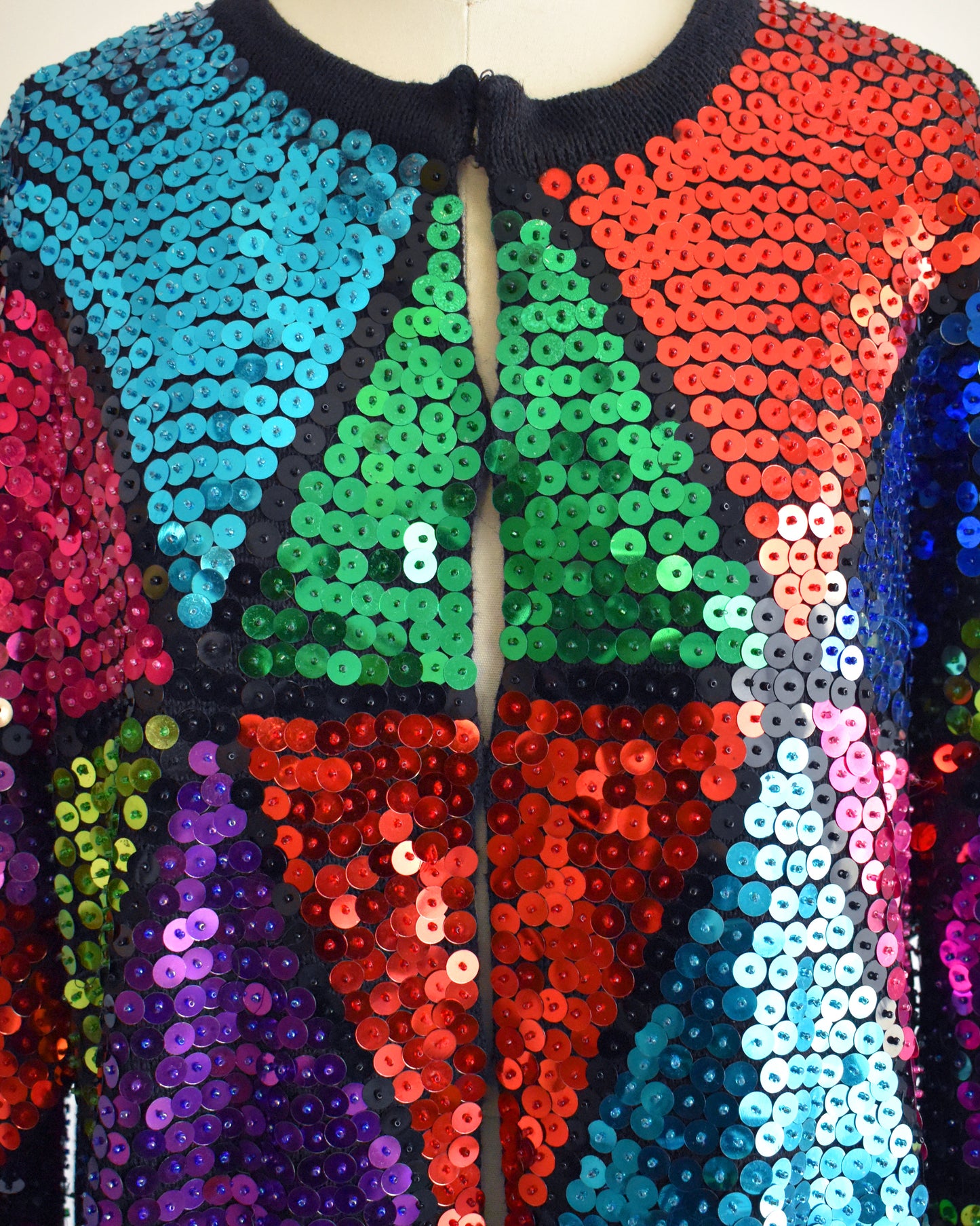 close up of a vintage 80s colorful sequin dress on a mannequin against a white background