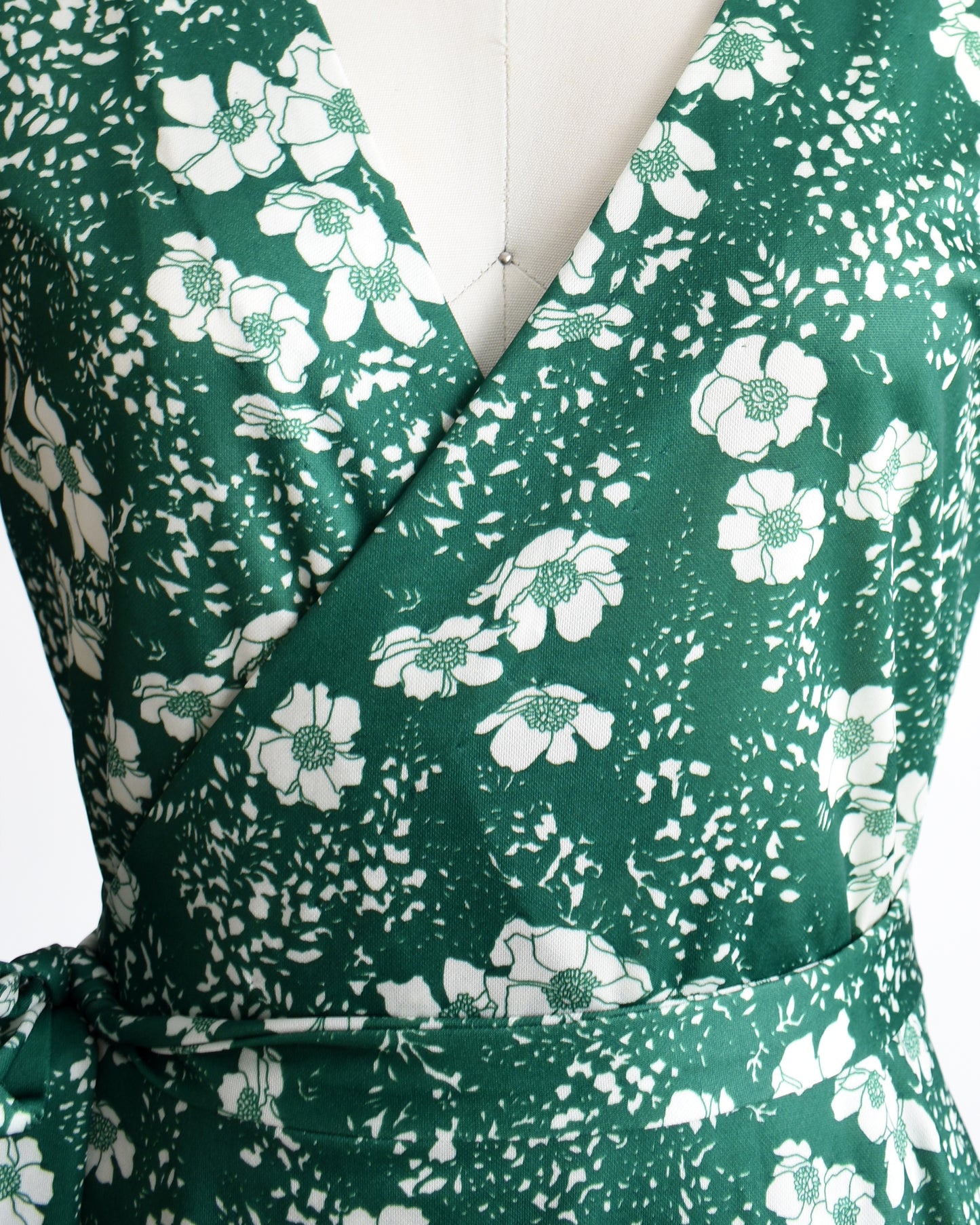 close up of a vintage 70s green and white floral wrap dress