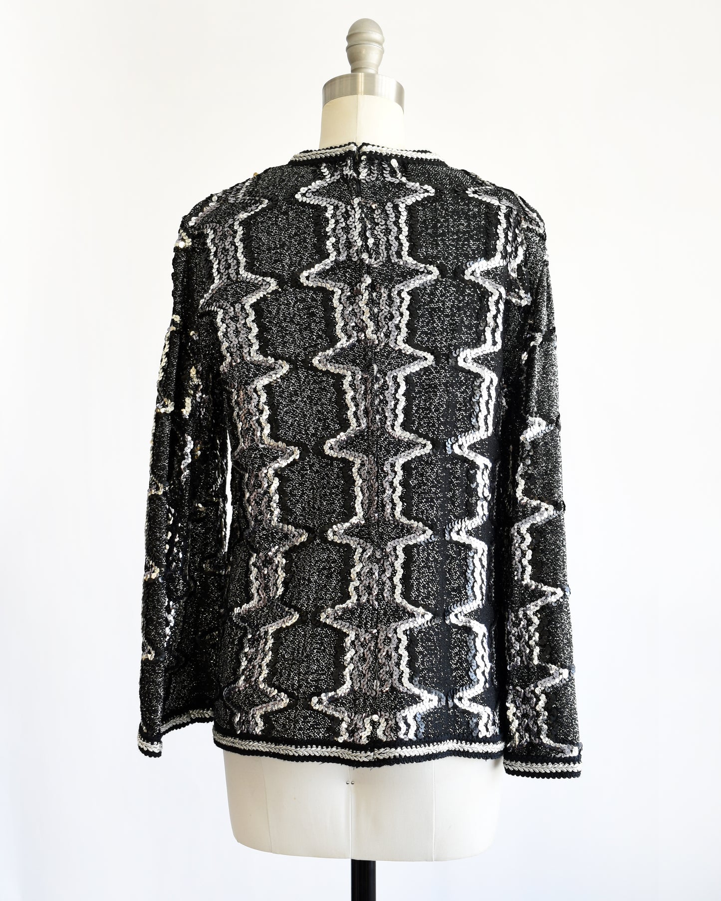 back view of a vintage 1970s/1980s Black and silver sequin top on a mannequin against a white background