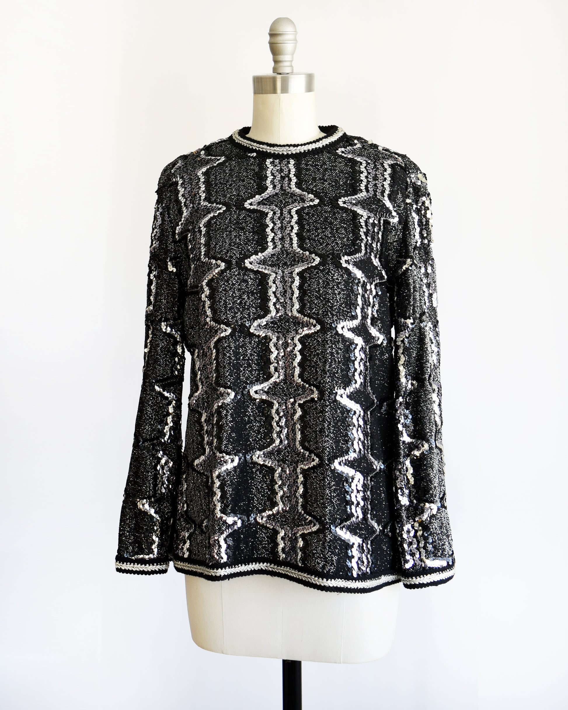 side front view of a vintage 1970s/1980s Black and silver sequin top on a mannequin against a white background