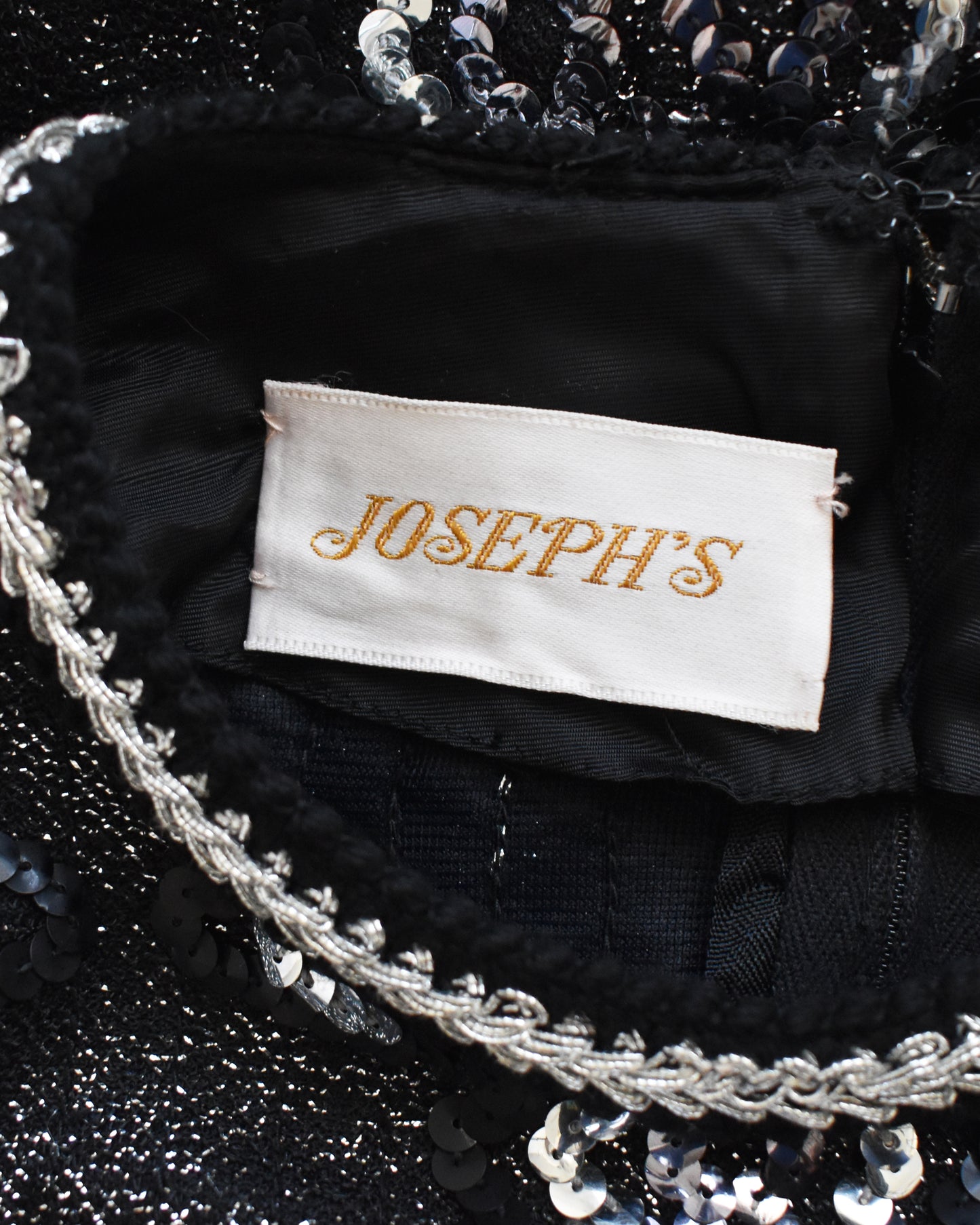 Close-up of a 'JOSEPH'S' label on a black sequined garment.