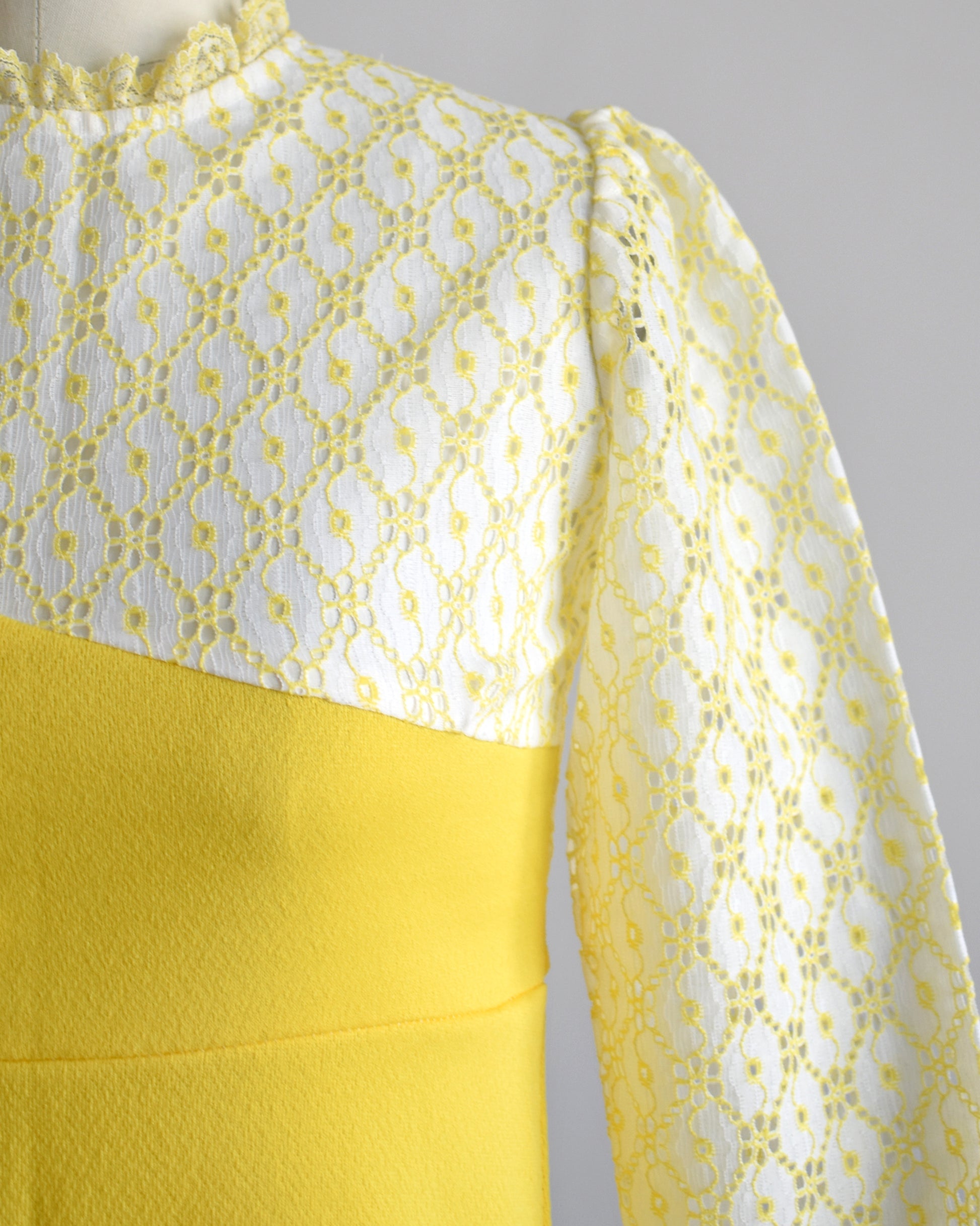 close up of the white and yellow lace detail on the bodice of the dress