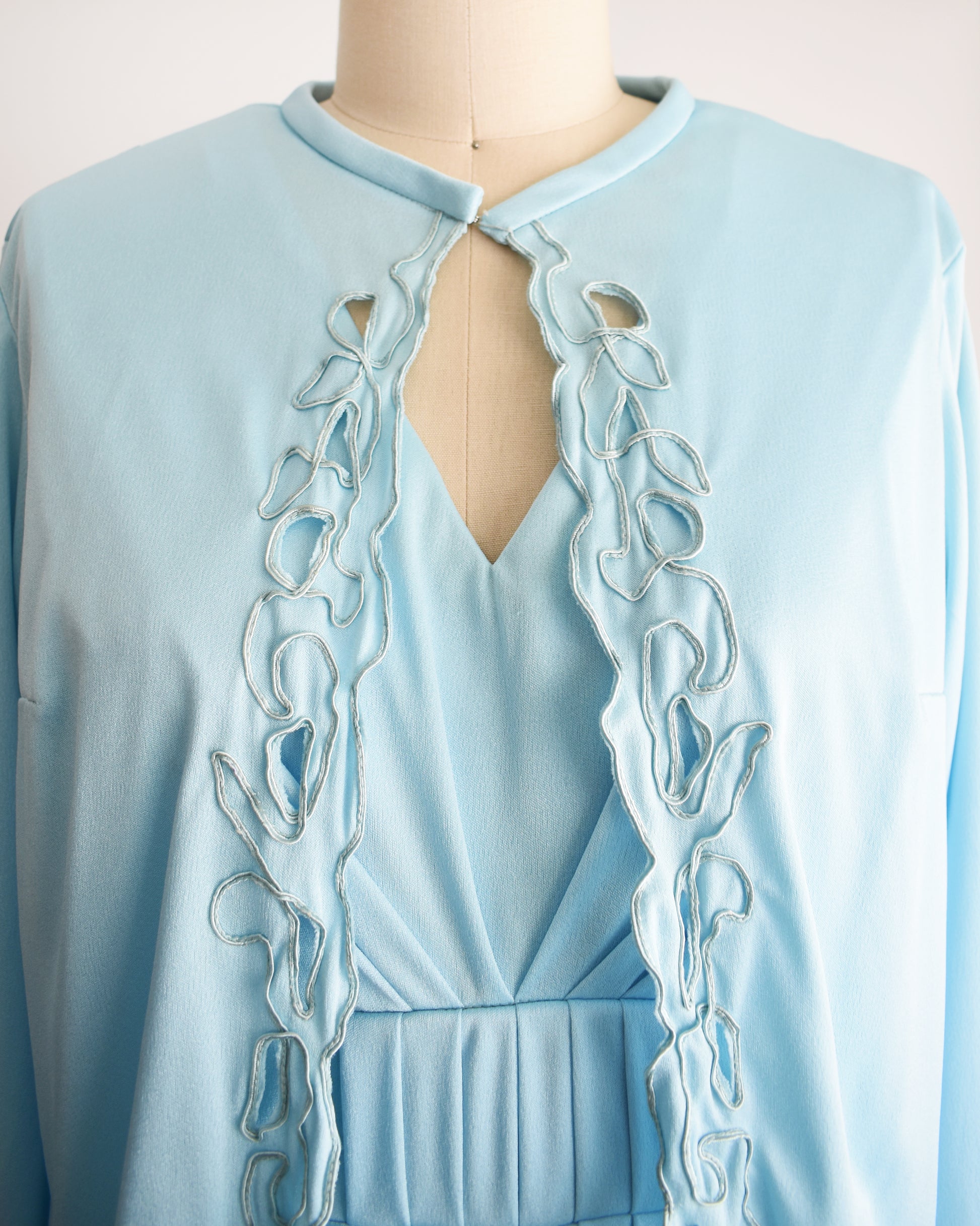 close up of the bodice of the dress and embroidered cut-out detail on the jacket