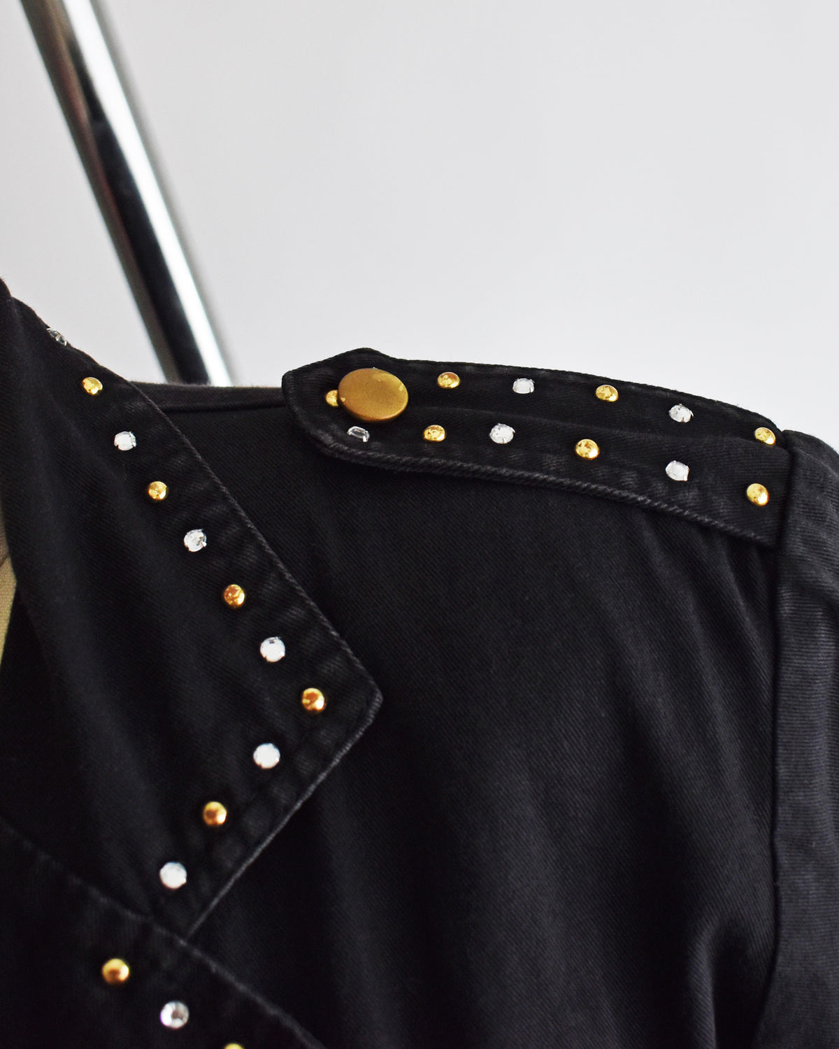 Close-up of the shoulder epaulets adorned with gold and silver studs and rhinestones