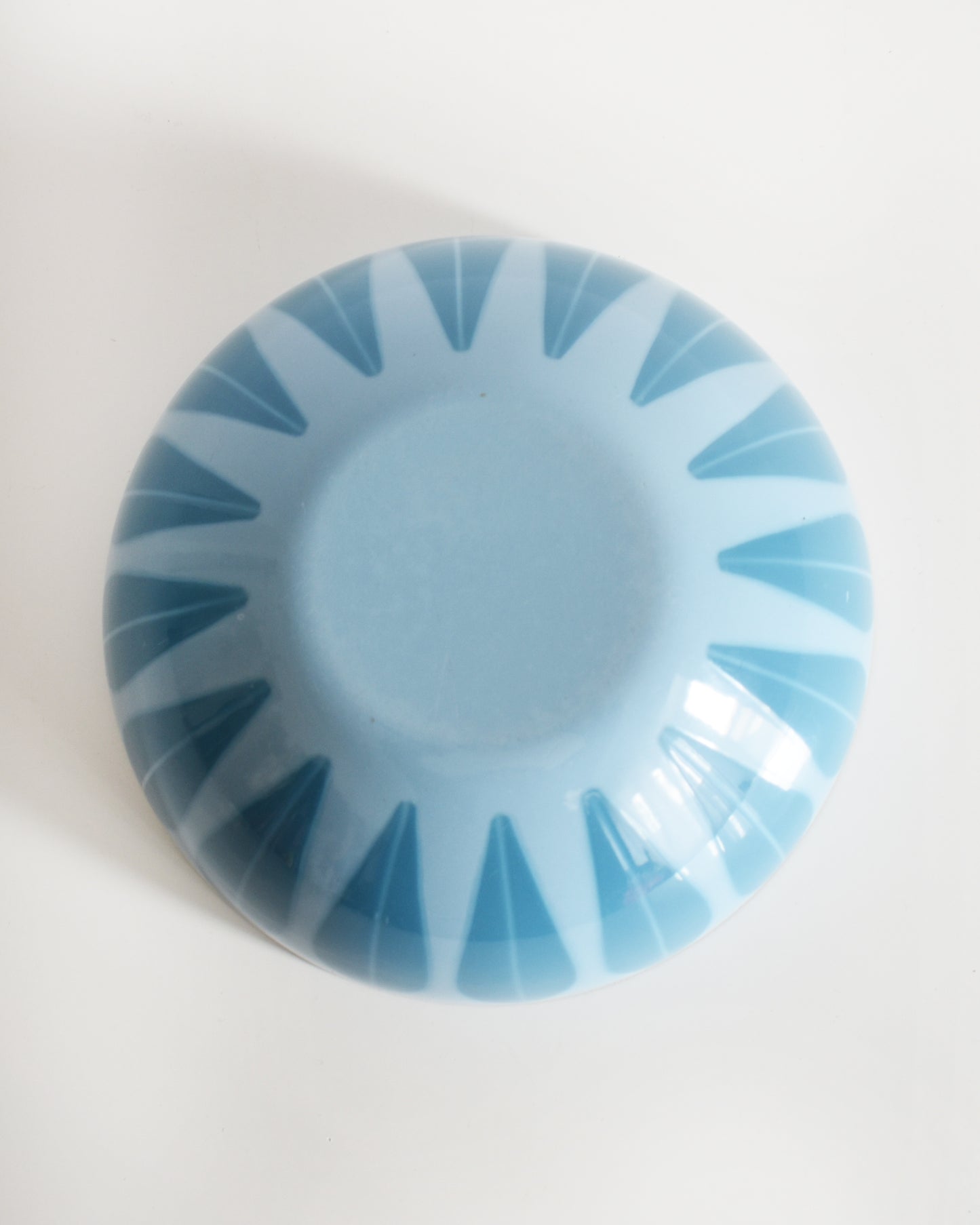 an ovehead shot of a vintage 1960s Cathrineholm lotus bowl against a white background that's turned over