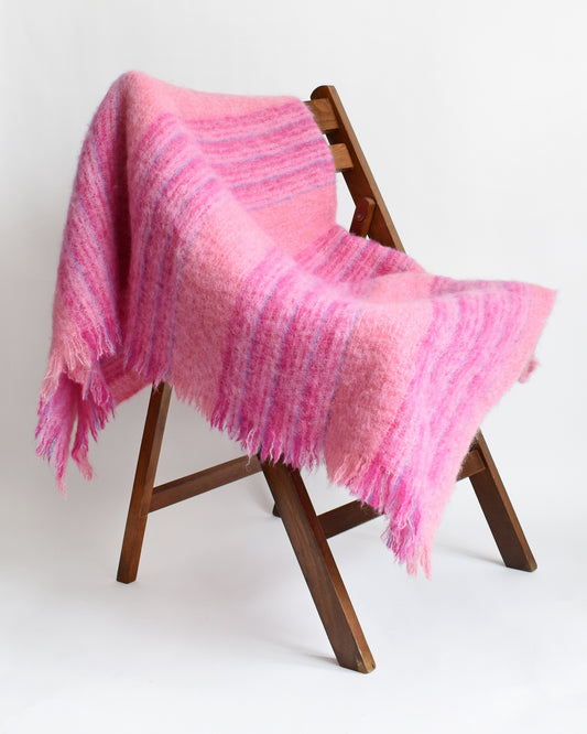 a vintage pink and purple striped mohair wool blanket draped on a chair