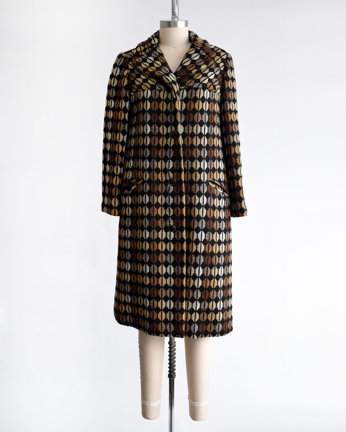 a vintage 1970s black and brown patterned coat on a mannequin against a white background