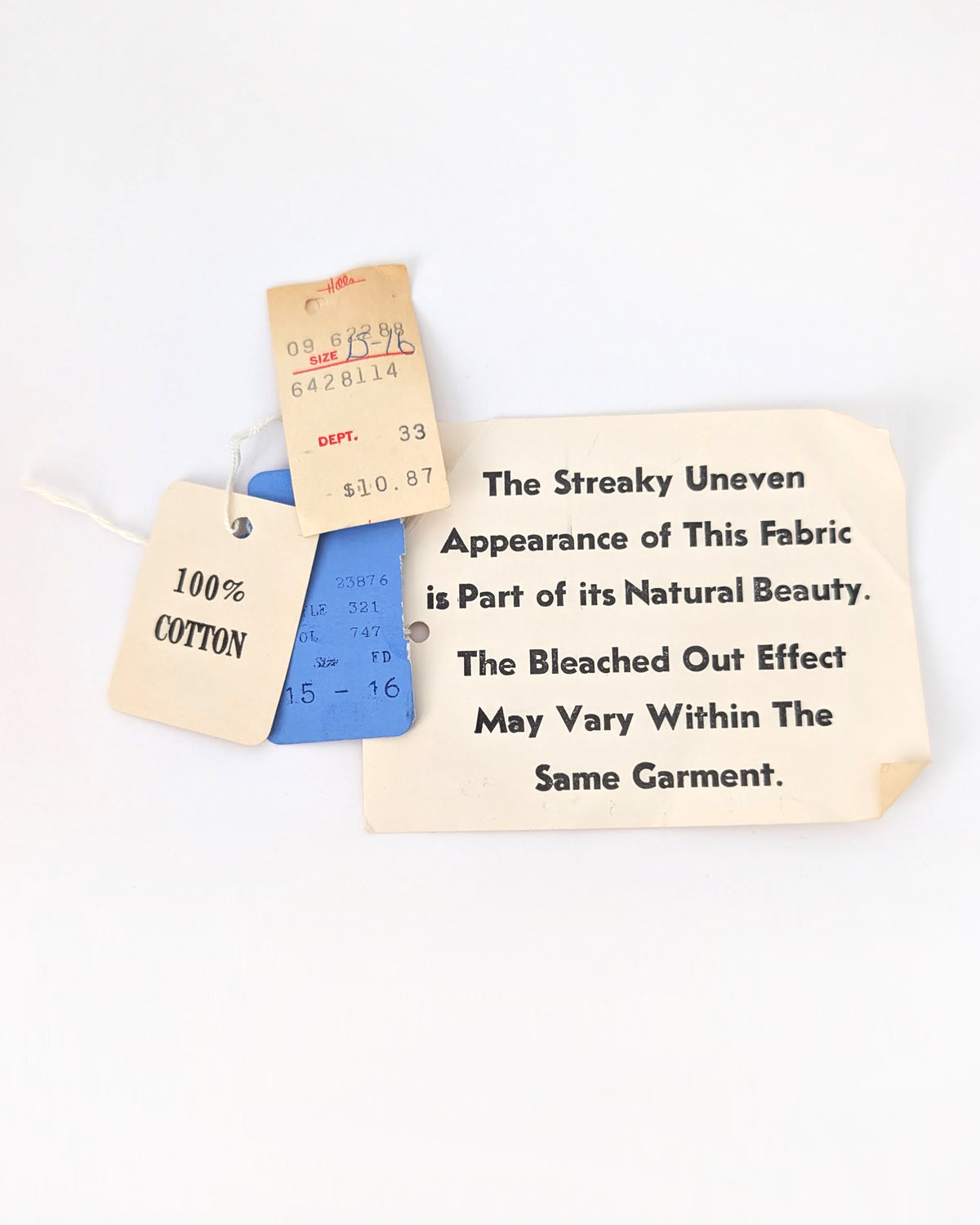 A set of vintage fabric sample tags and labels on a white background. The tags include a blue cotton sample tag marked '100% COTTON $10.
