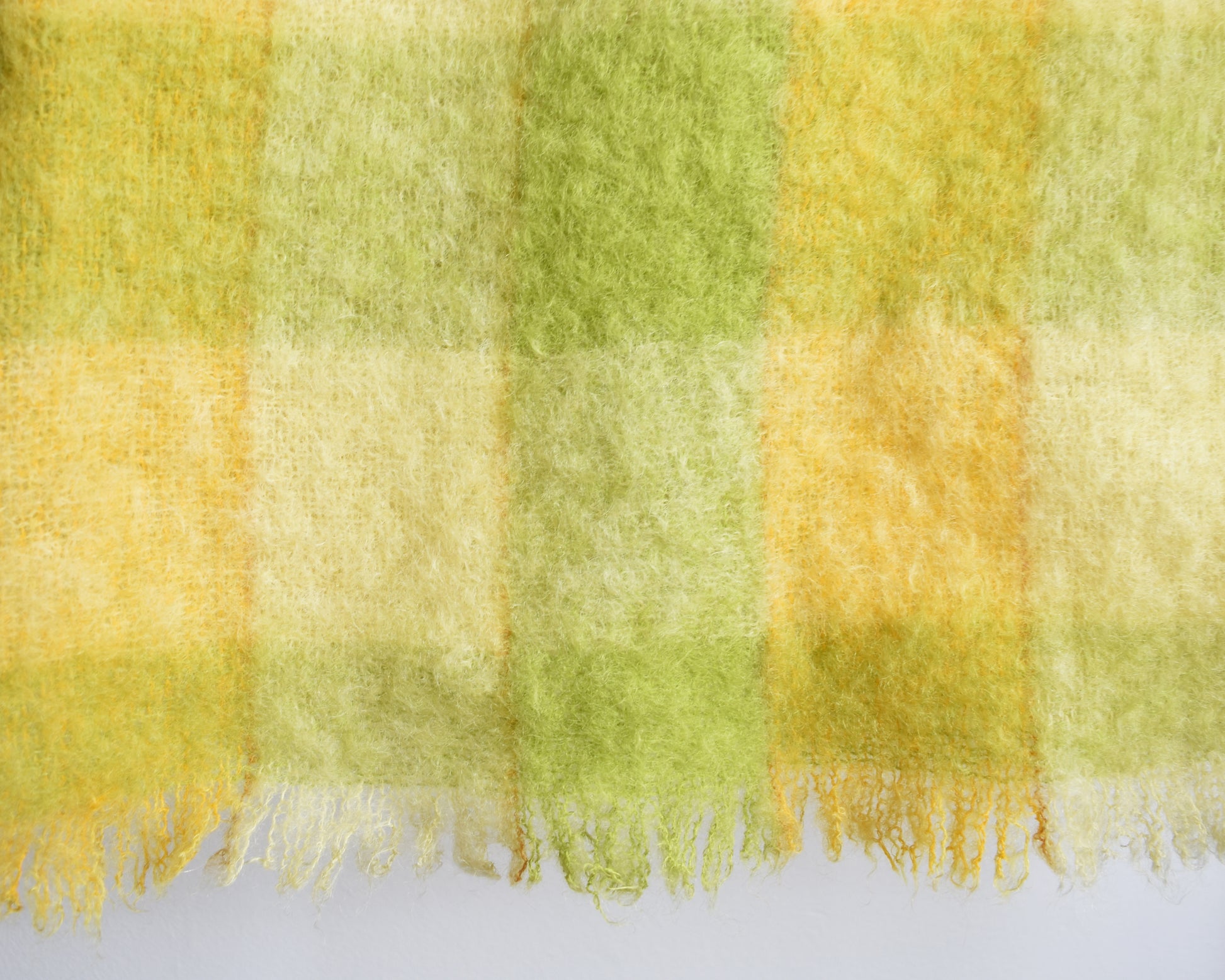 close up of a vintage yellow and green plaid mohair wool blanket 