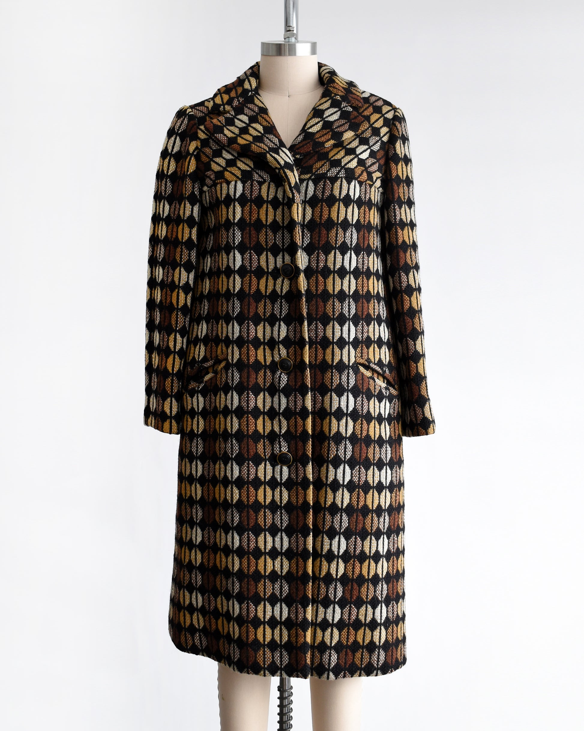 a vintage 1970s black and brown patterned coat on a mannequin against a white background