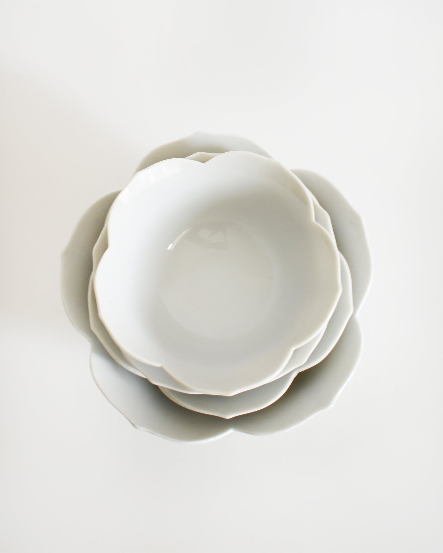 overhead shot of a set of white ceramic bowls on a light gray background