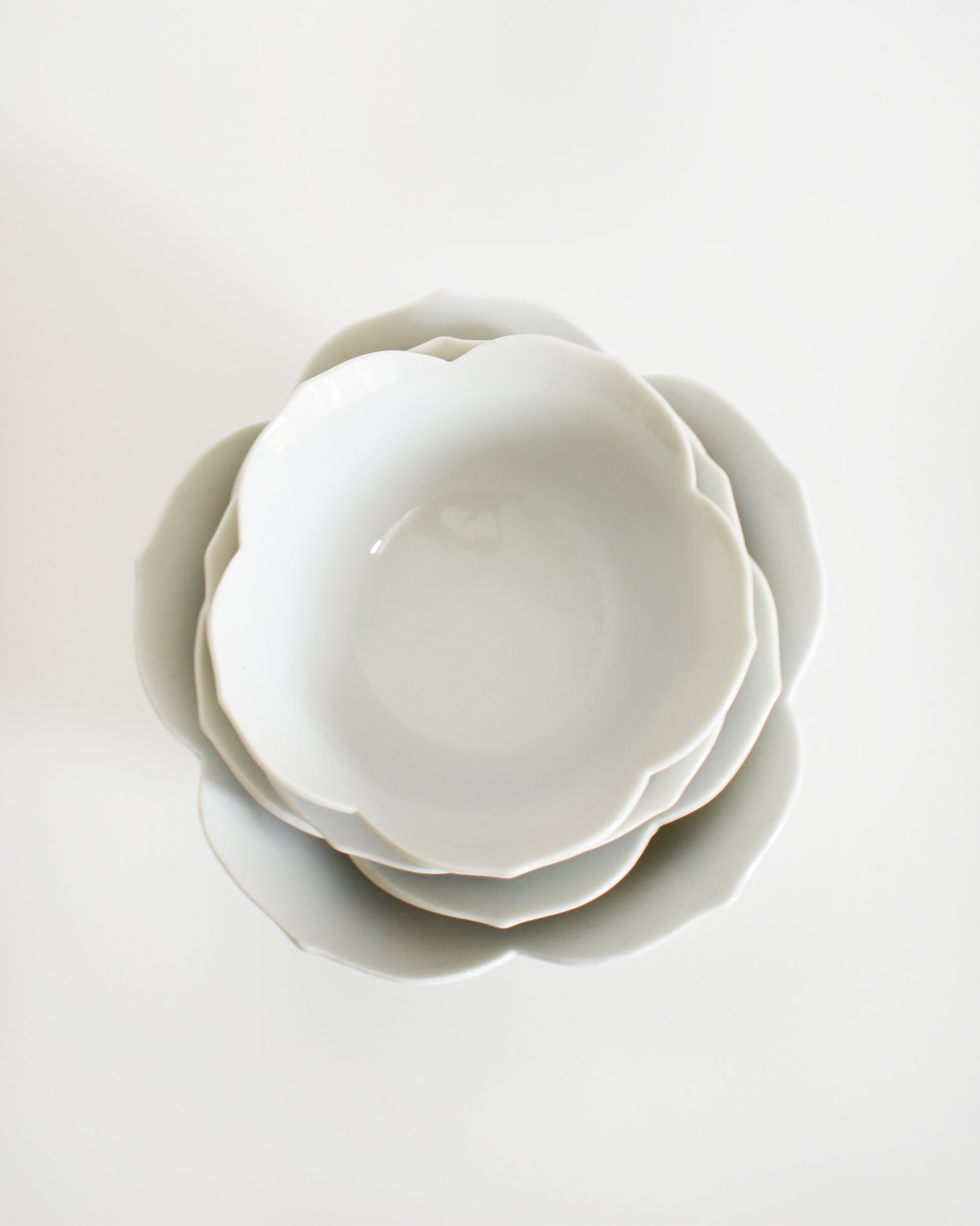 overhead shot of a set of white ceramic bowls on a light gray background