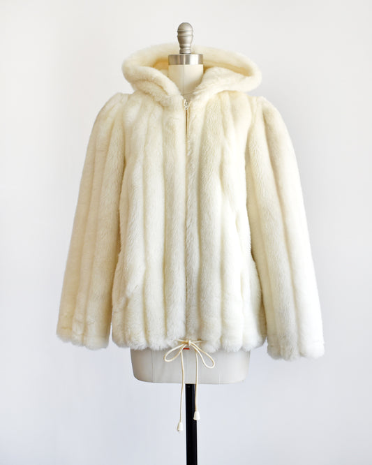 a vintage 1980s cream faux fur hooded coat with a drawstring on the bottom.