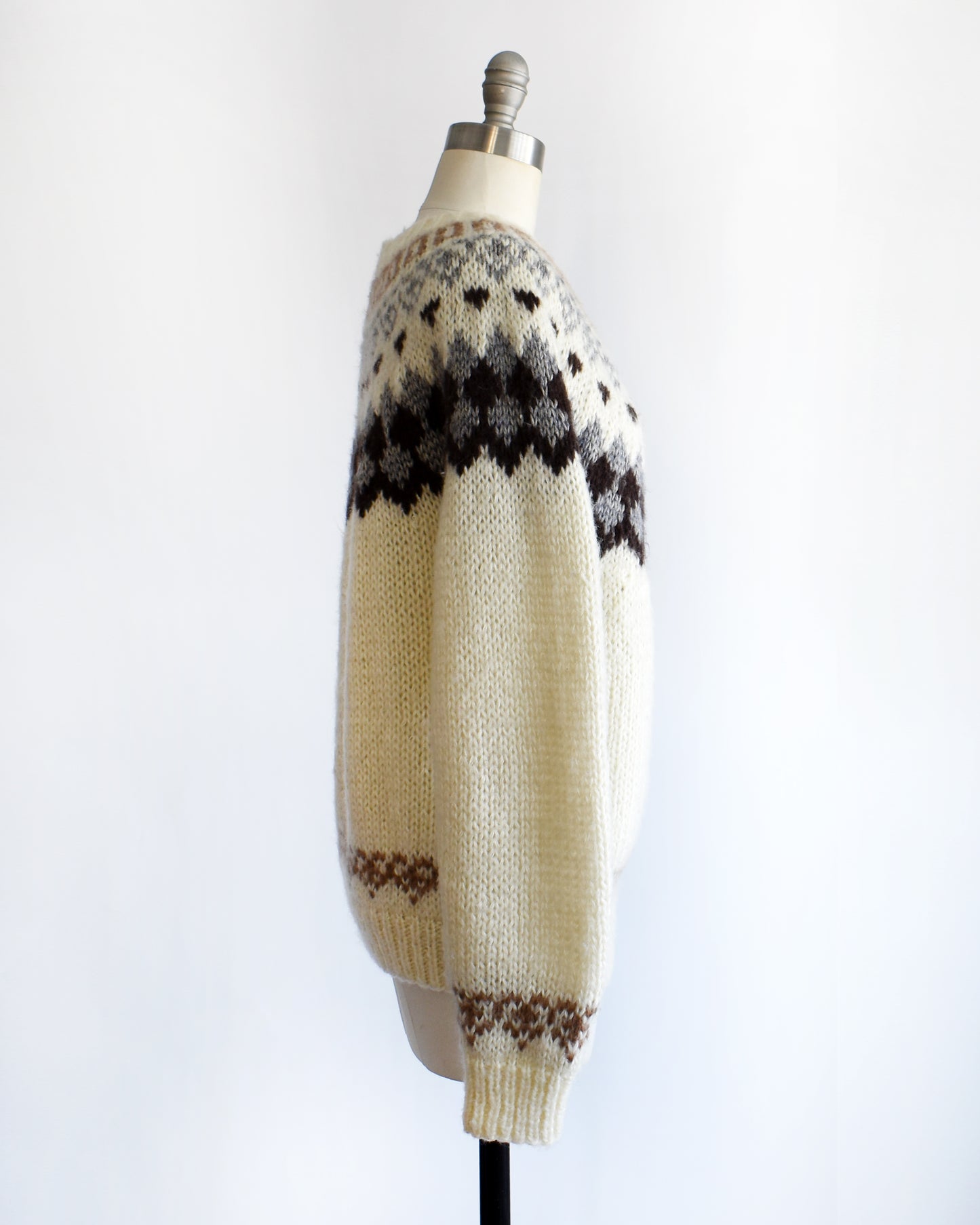 side view of a vintage 1970s Fair Isle zip up sweater on a mannequin against a white background