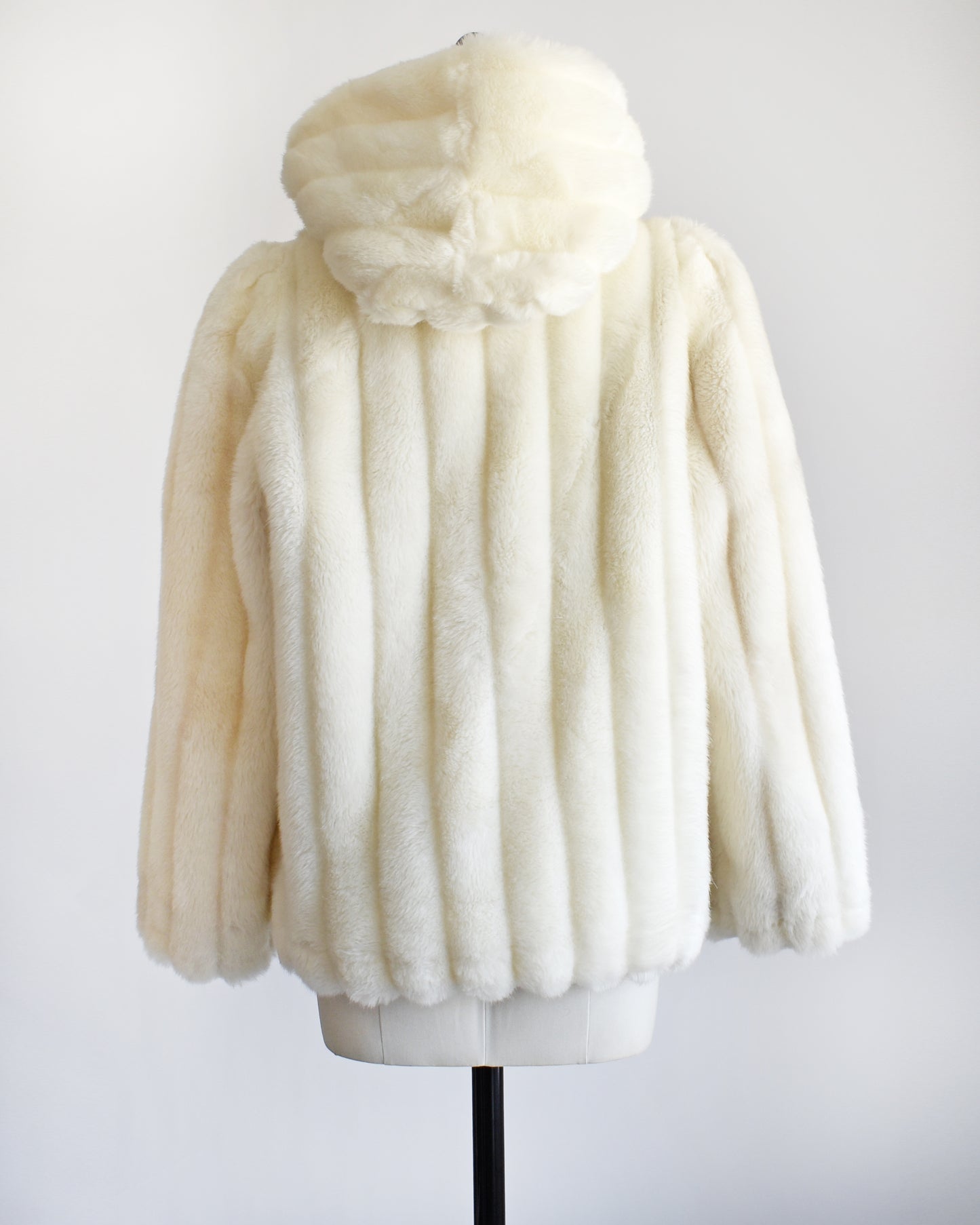 back view of a vintage 1980s cream faux fur hooded coat.