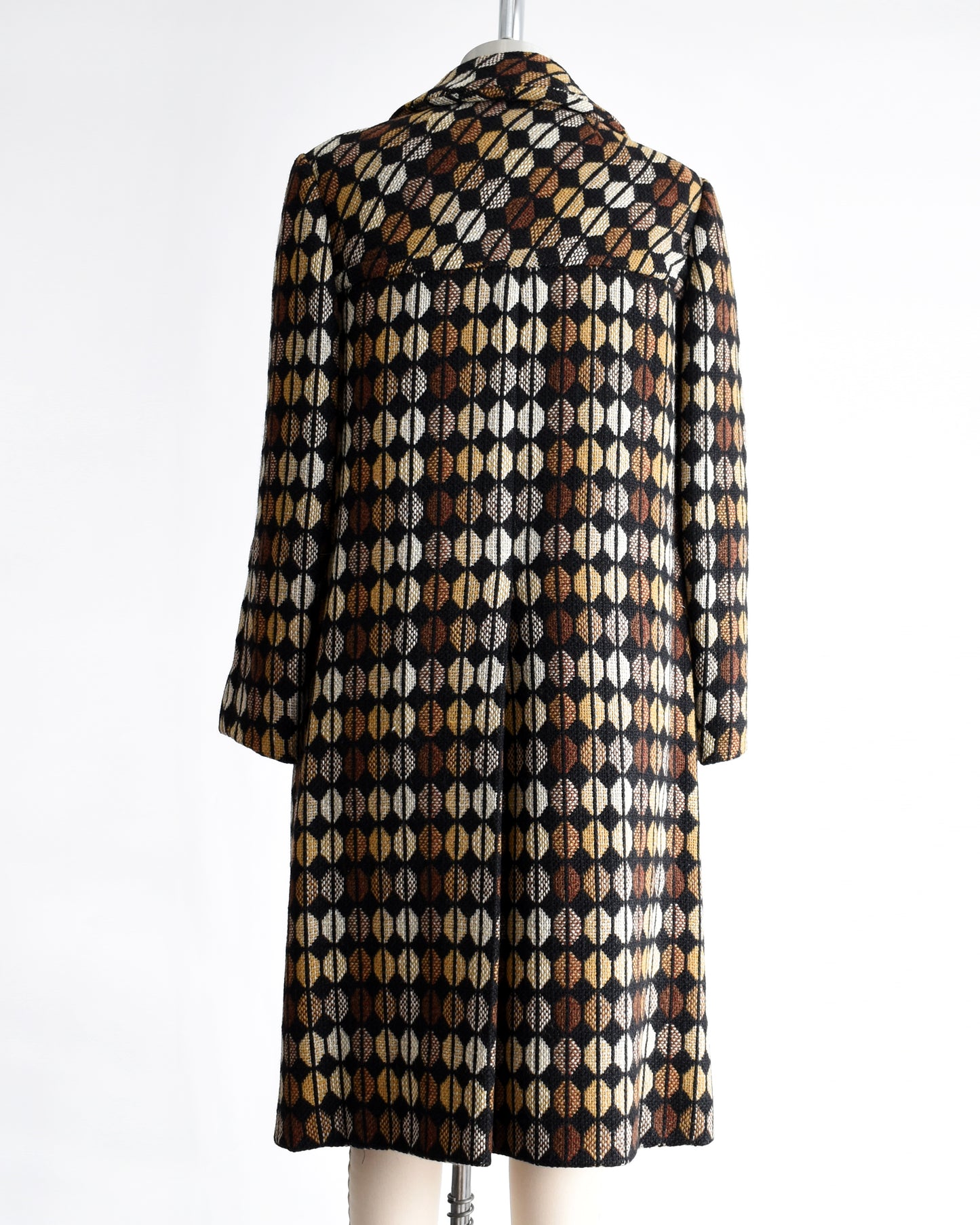back view of a vintage 1970s black and brown patterned coat on a mannequin against a white background