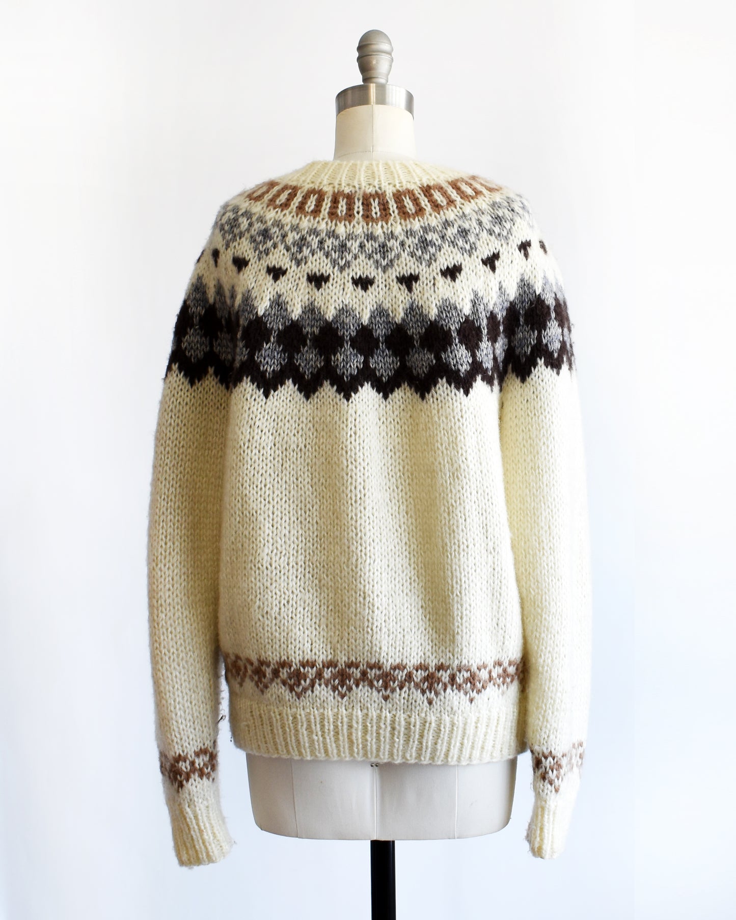 back view of a vintage 1970s Fair Isle zip up sweater on a mannequin against a white background