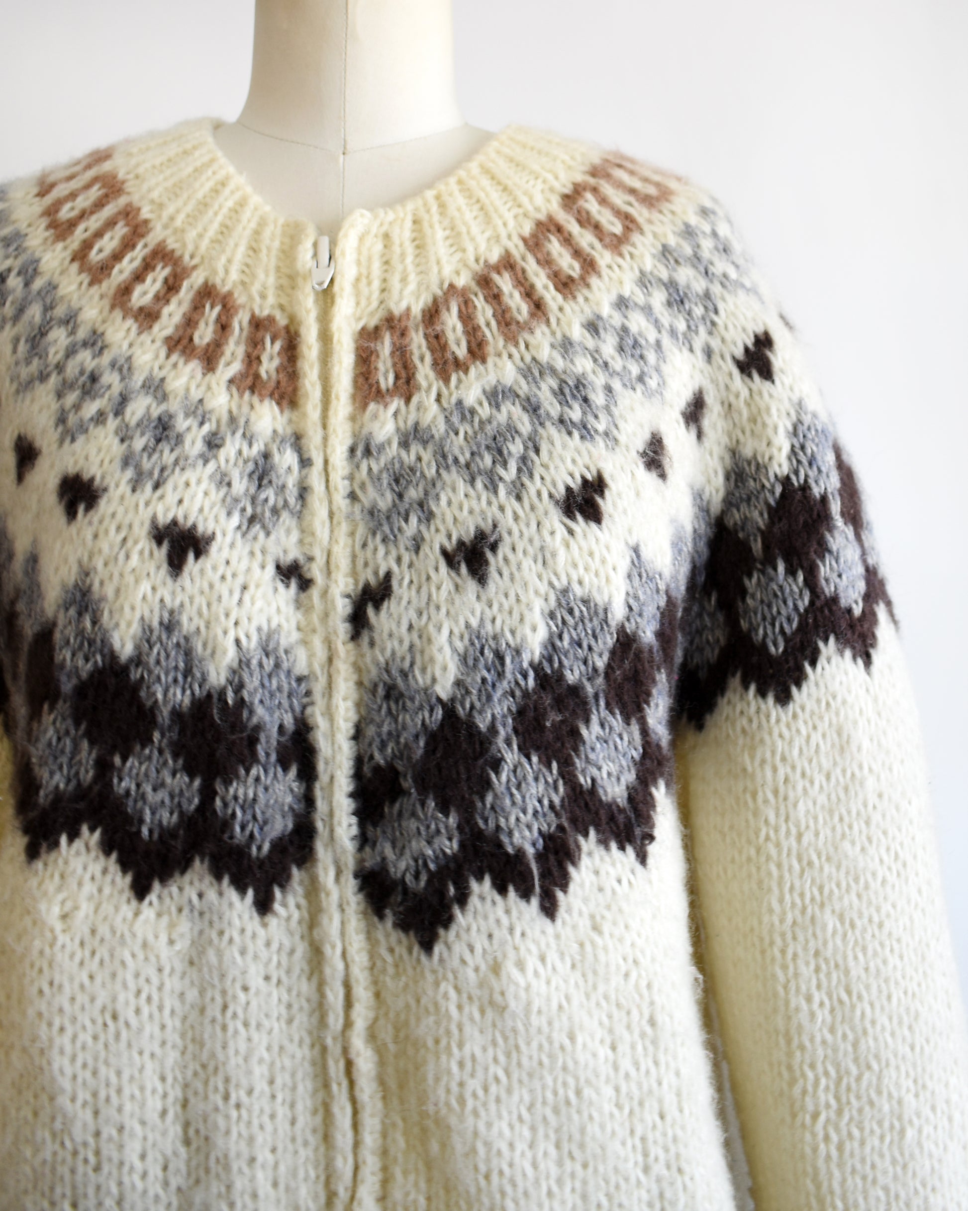 close up of the shoulder area of a vintage 1970s Fair Isle zip up sweater on a mannequin against a white background