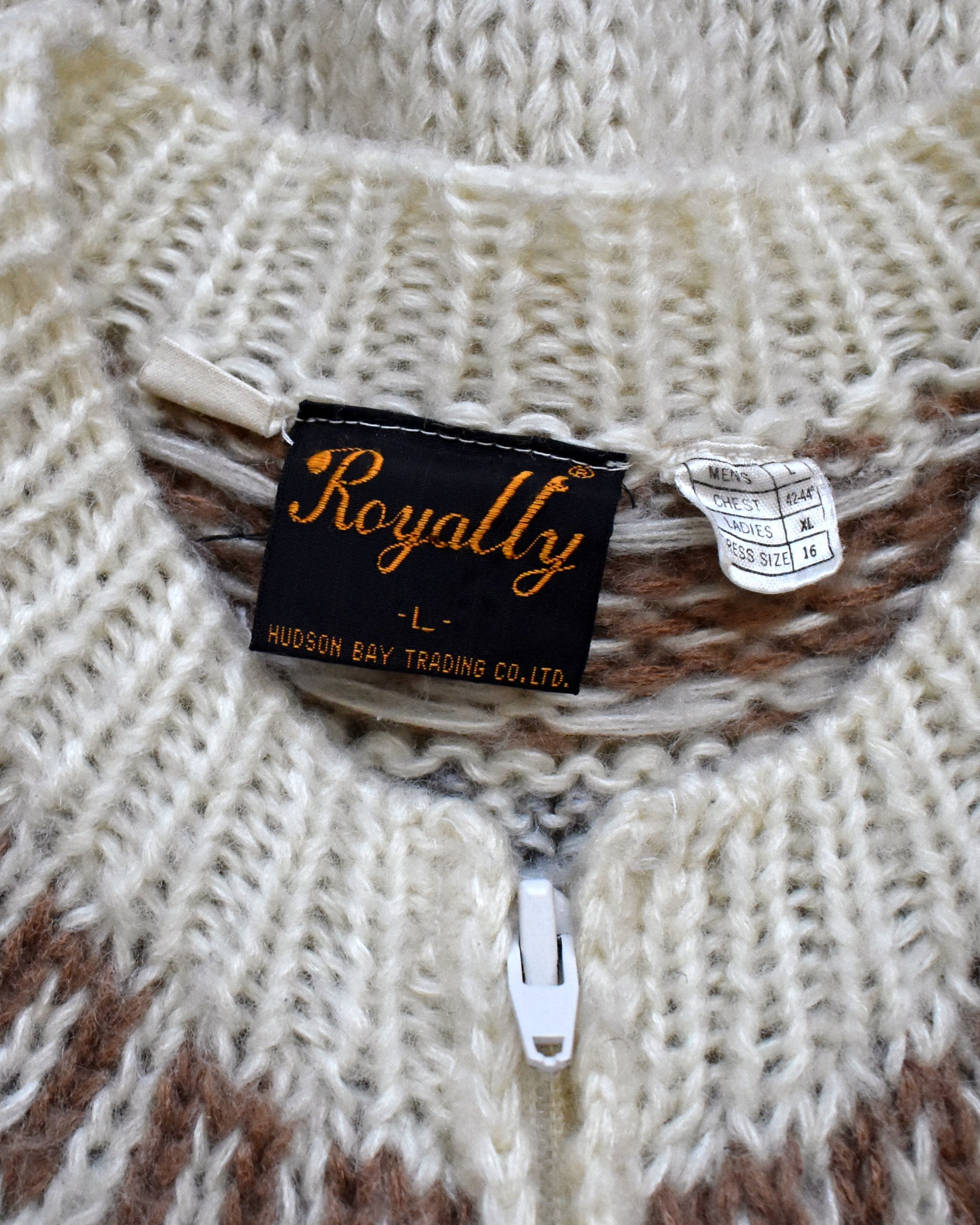 Close-up of a knit sweater with a 'Royally' label on a textured background