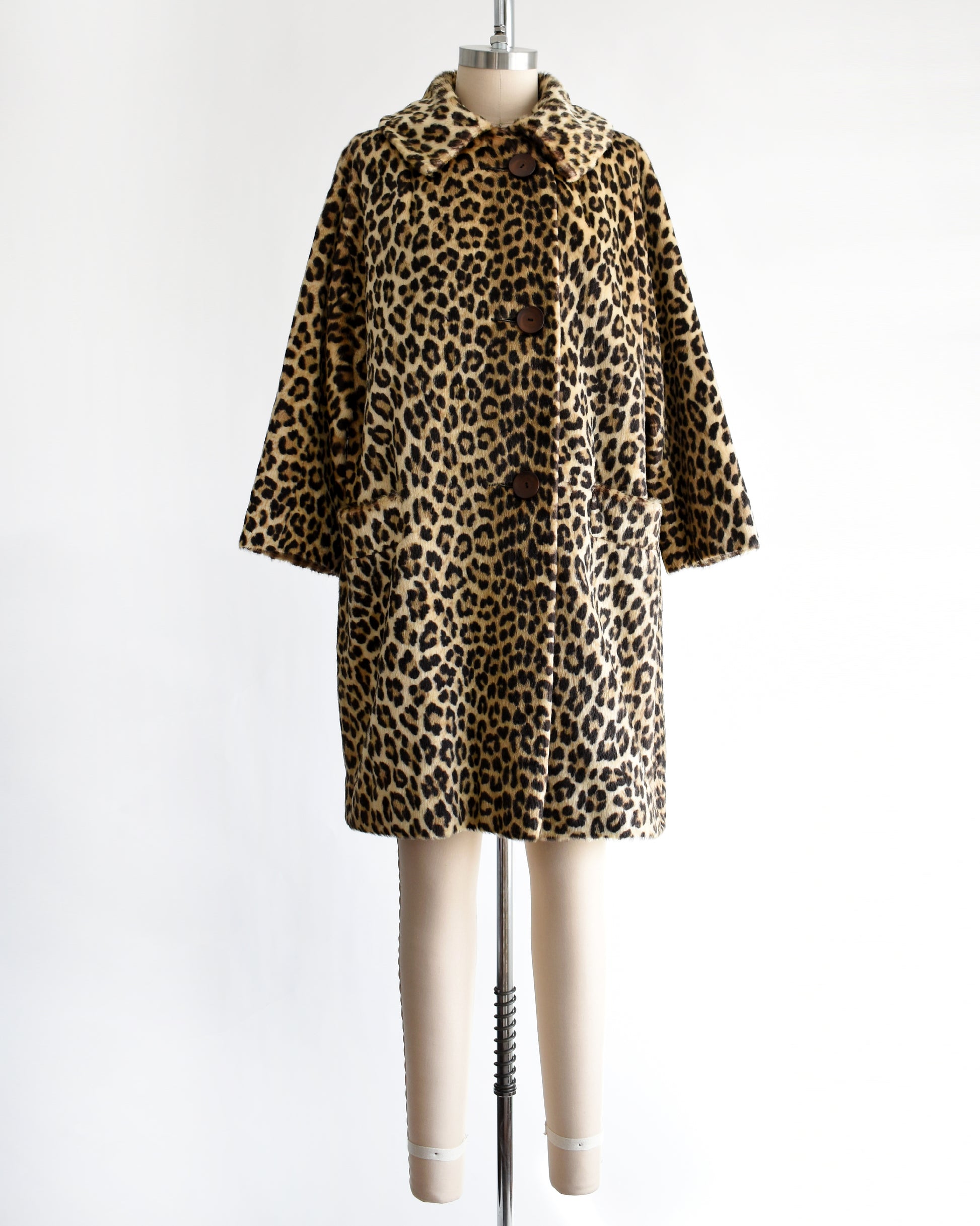 a vintage 1960s faux fur leopard print coat on a dress form against a white background