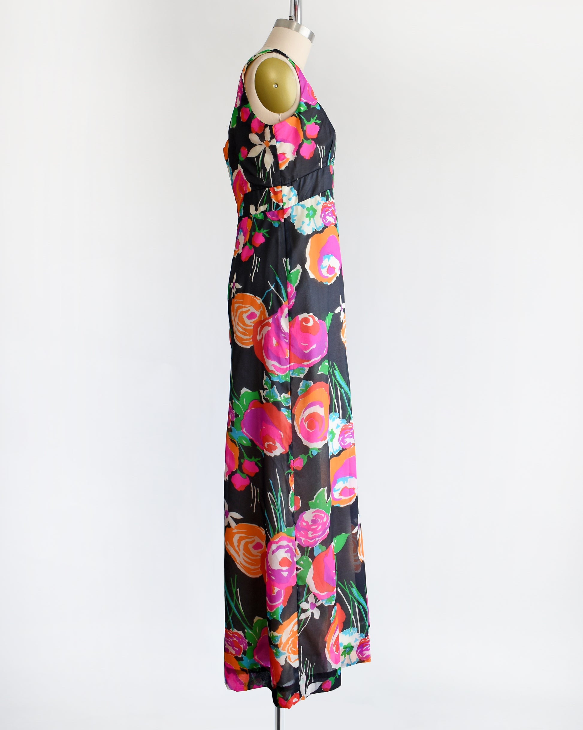 side view of a vintage 1970s black floral print jumpsuit by Malia on a dress form