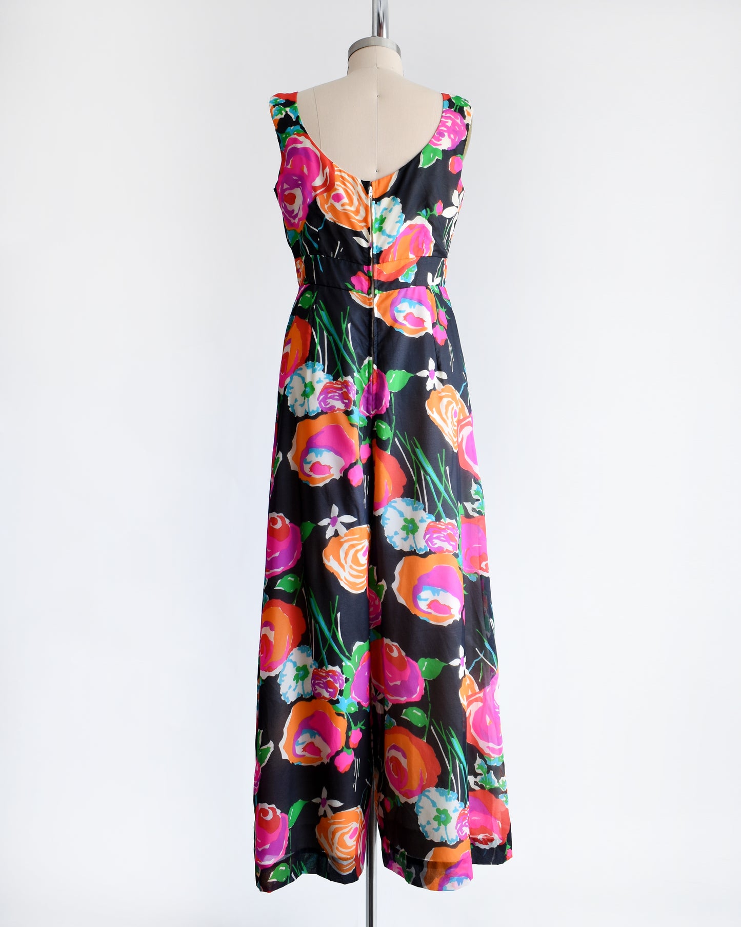 back view of a vintage 1970s  black floral print jumpsuit by Malia on a dress form