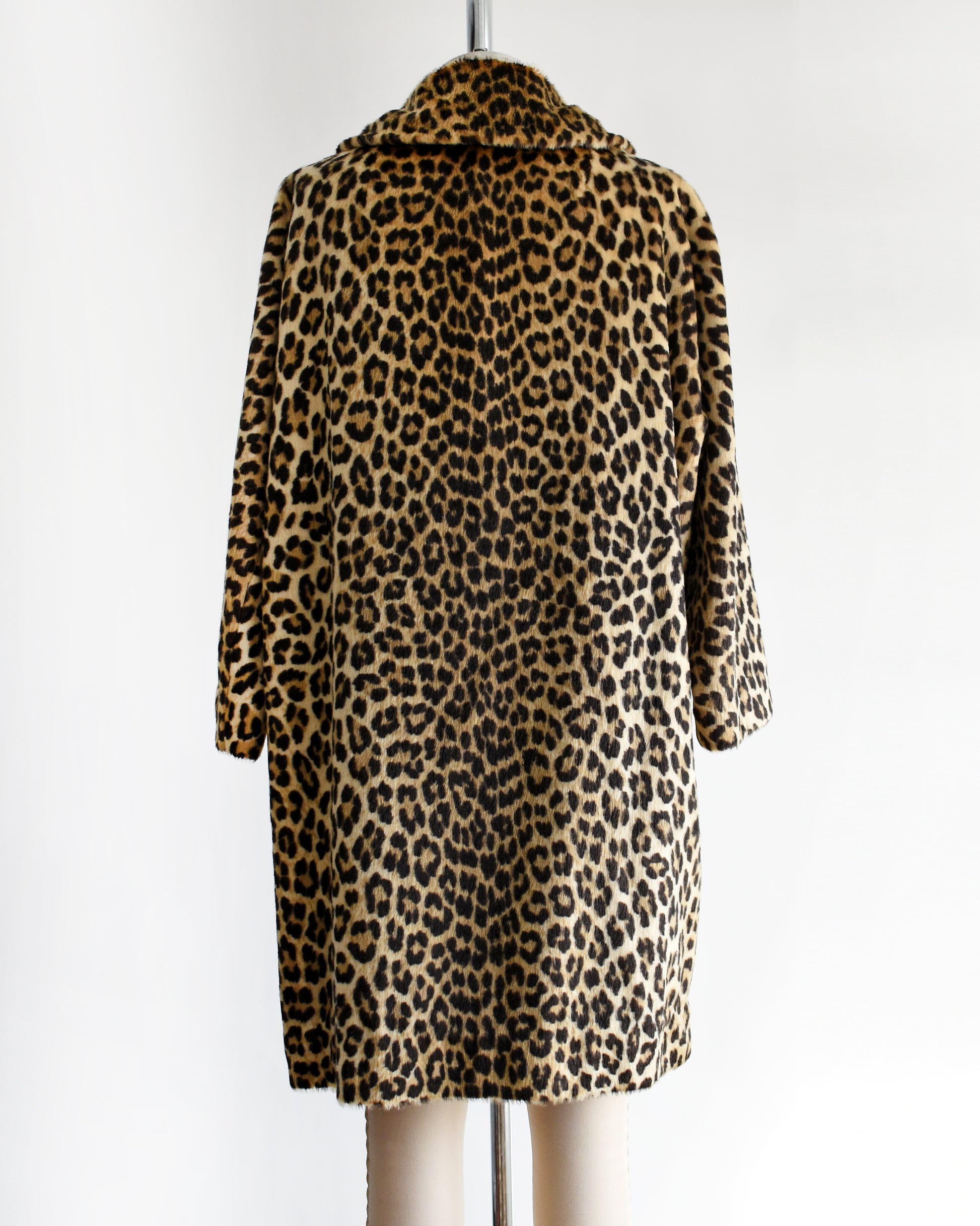 back view of a vintage 1960s faux fur leopard print coat on a dress form against a white background