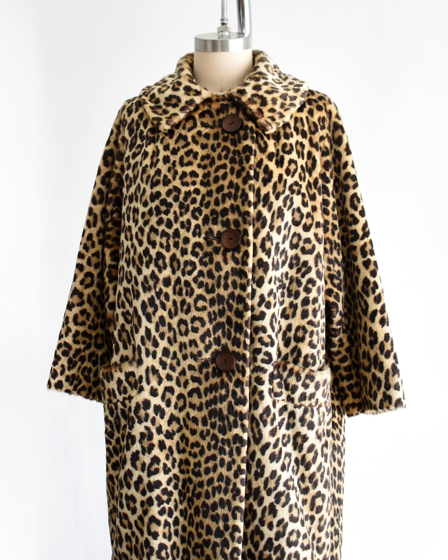 side front view of a vintage 1960s faux fur leopard print coat on a dress form against a white background